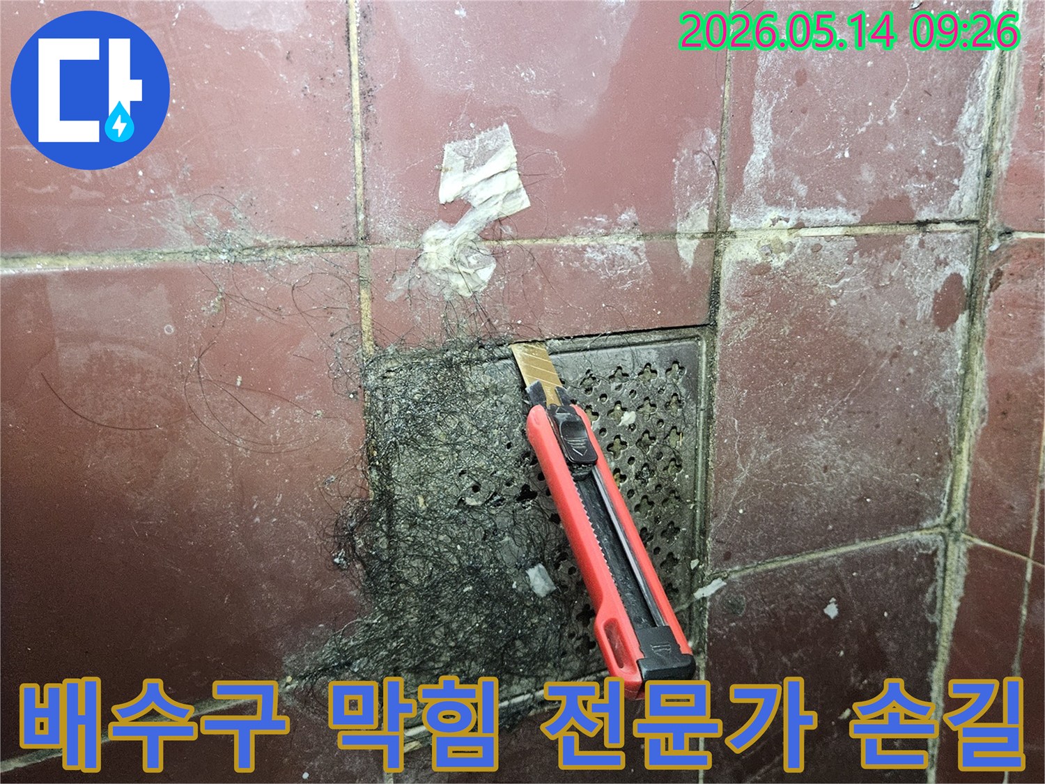 오래된 욕실 배수구에 엉킨 머리카락과 슬러지를 커터칼로 긁어내며 누수 해결 전문가의 손길을 보여주는 모습