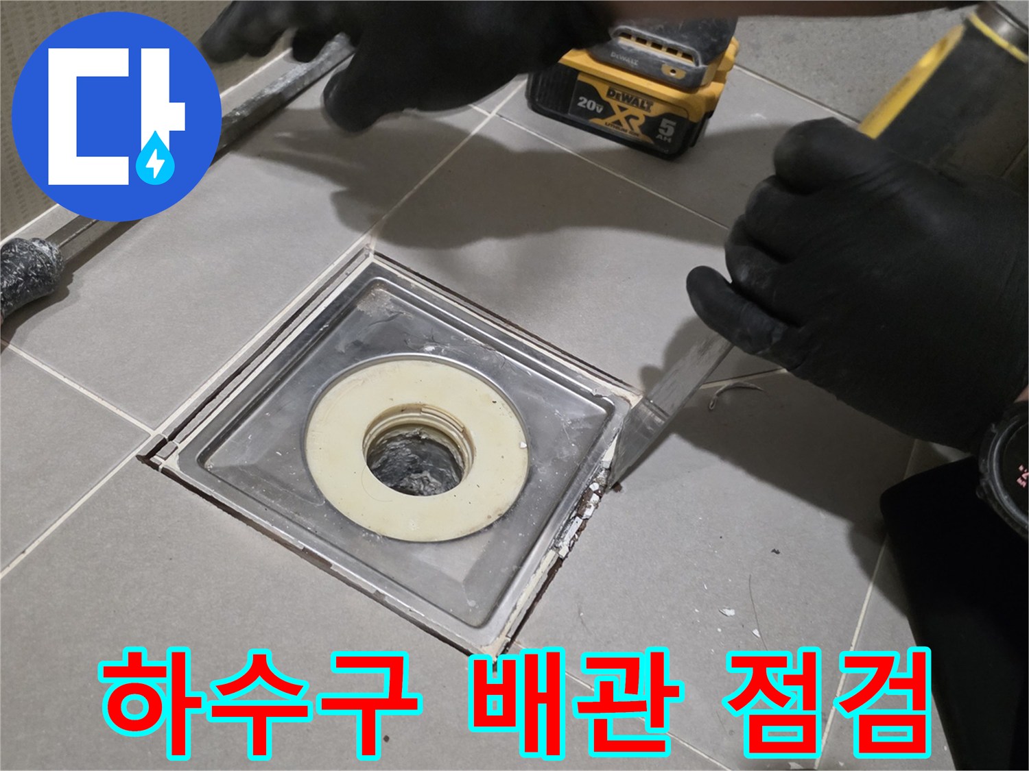 도구를 사용하여 배수구 주변 타일을 제거하는 작업자 손