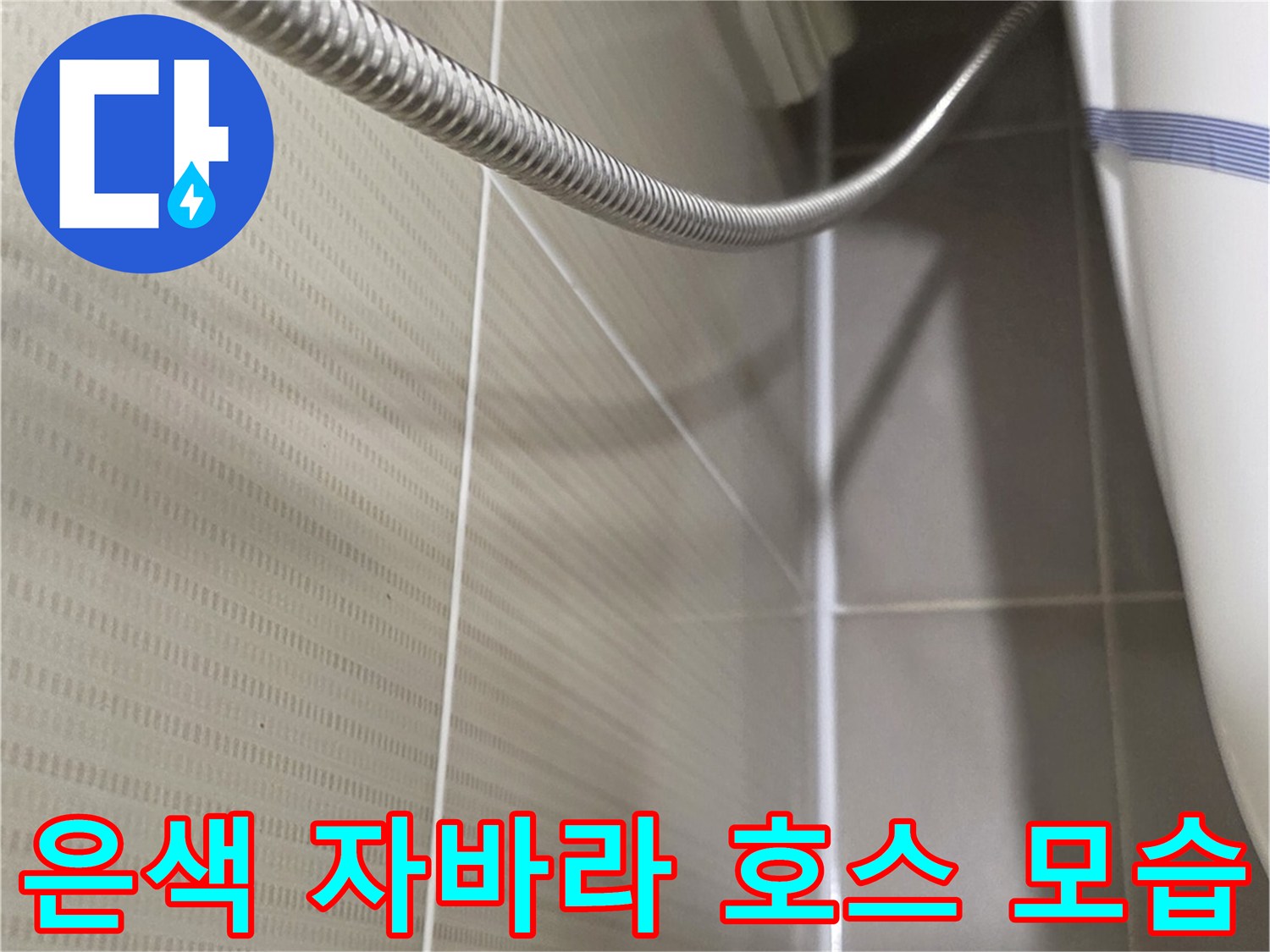 벽면 타일에 연결된 유연한 금속 재질의 샤워 호스