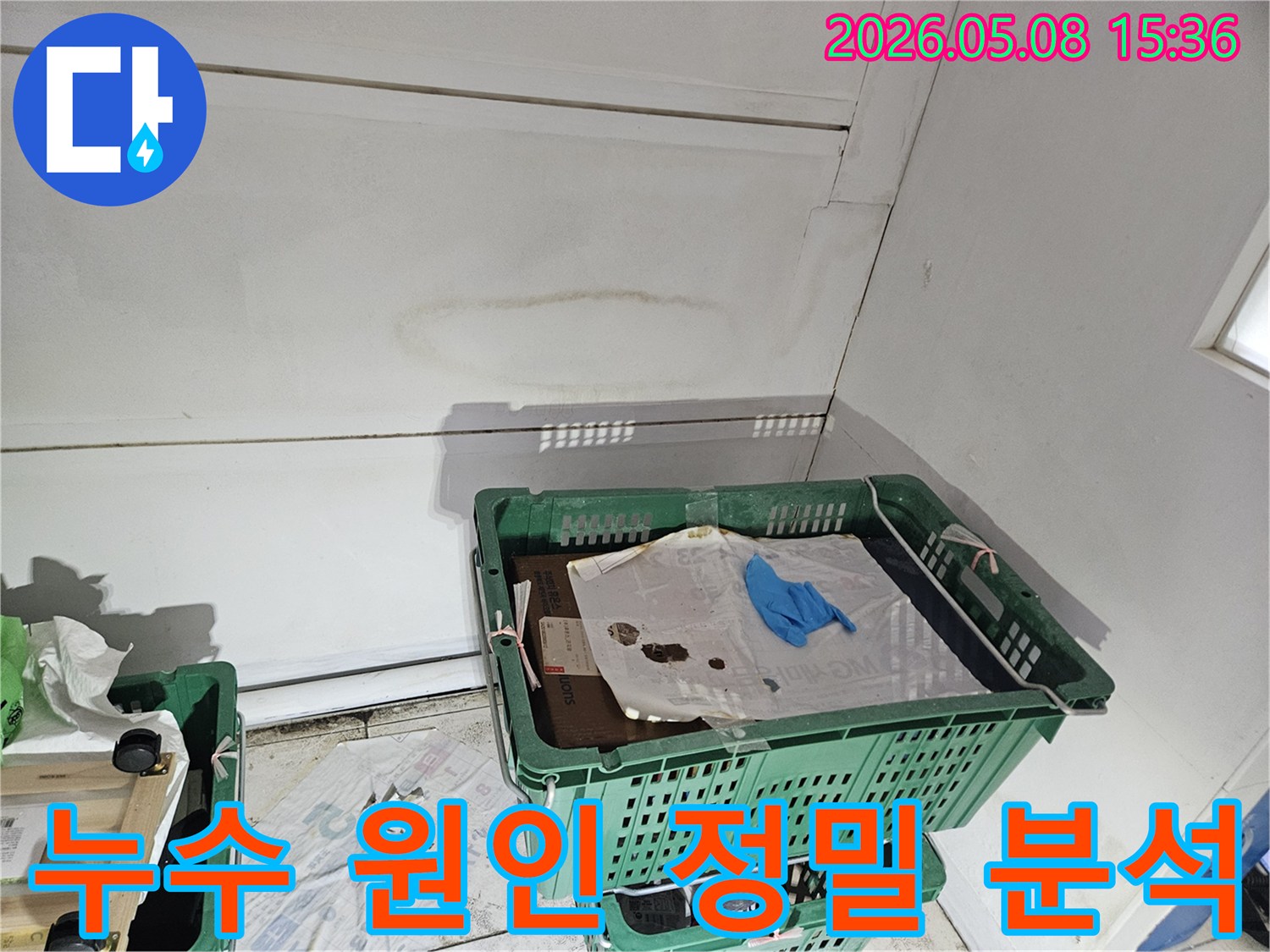 천안 동남구의 건물 내부에서-누수 흔적이 발견된 천장과 벽면 모서리를-전문가가 다양한 각도에서 분석하며-누수의 근본적인 원인을 파악하는 이미지