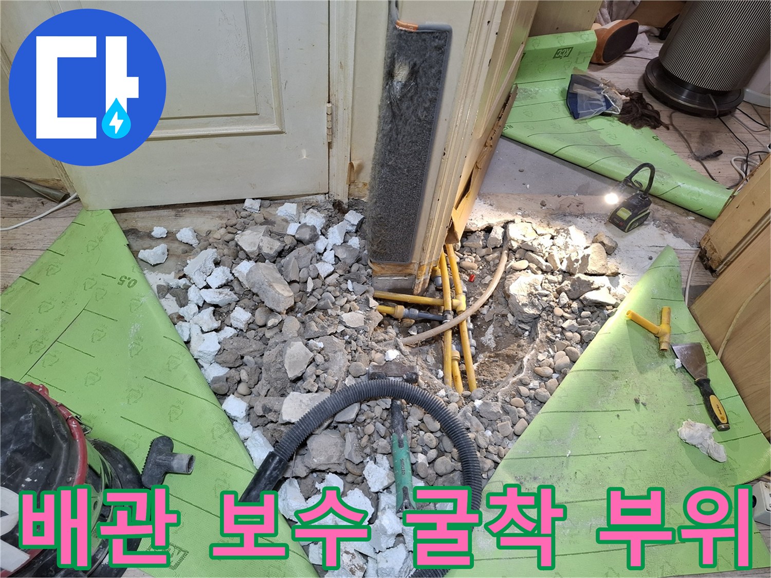 시멘트 파편과 함께 드러난 노란색 배관 및 청소 장비