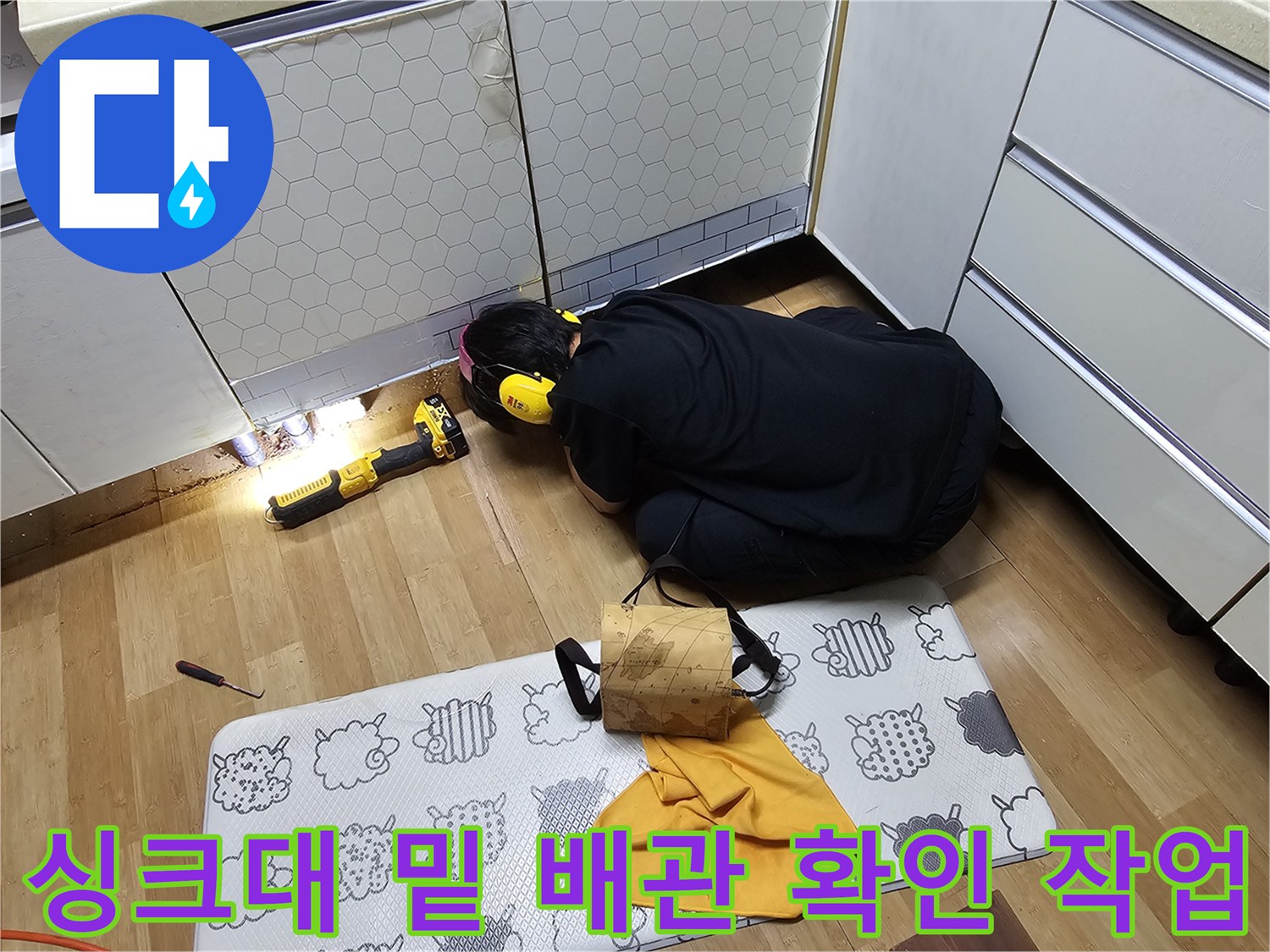 작업자가 좁은 싱크대 밑에서-배관 상태를 살피는 장면