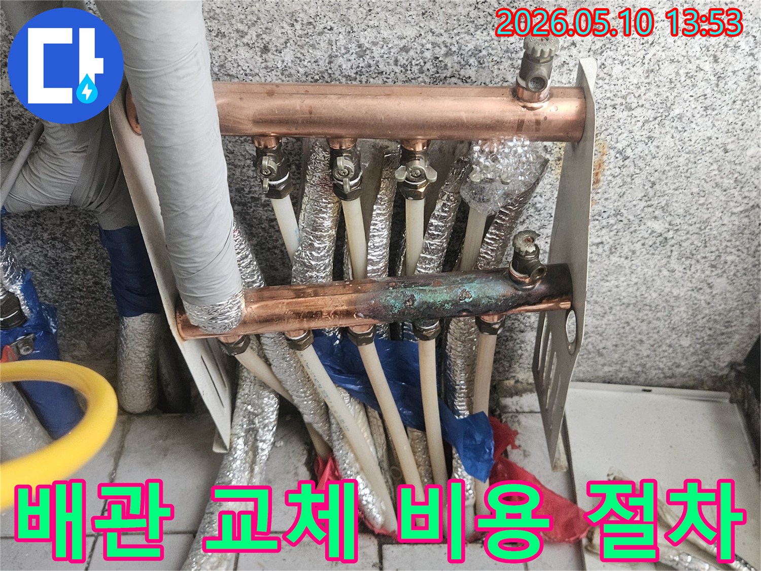 오래된 동파이프 난방 분배기가-심하게 부식되고-노후화가 진행되어-배관 교체가 시급함을 보여주며-교체 비용과 절차에 대한-정보가 필요한-현장 이미지입니다.
