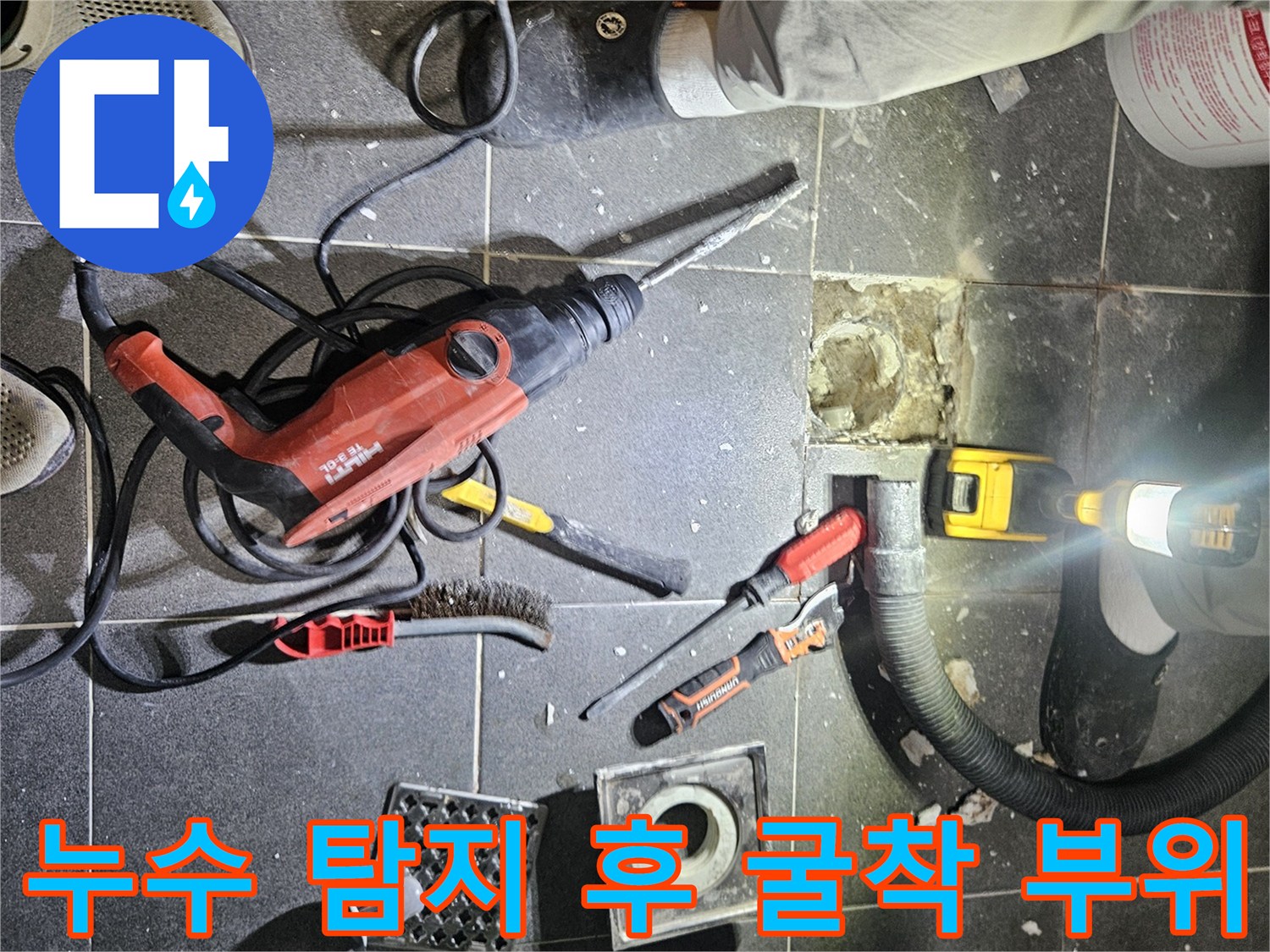 누수 지점을 찾기 위해 타일을 걷어내고 배관을 노출시킨 작업 현장입니다.