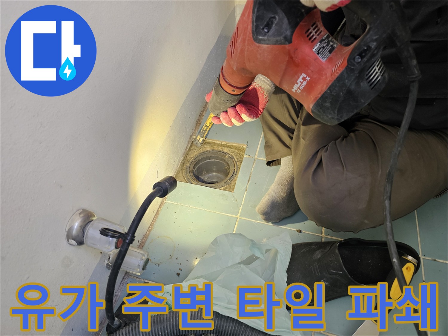 드릴로 작업 중인-배수구 유가 인근의 타일 제거 장면