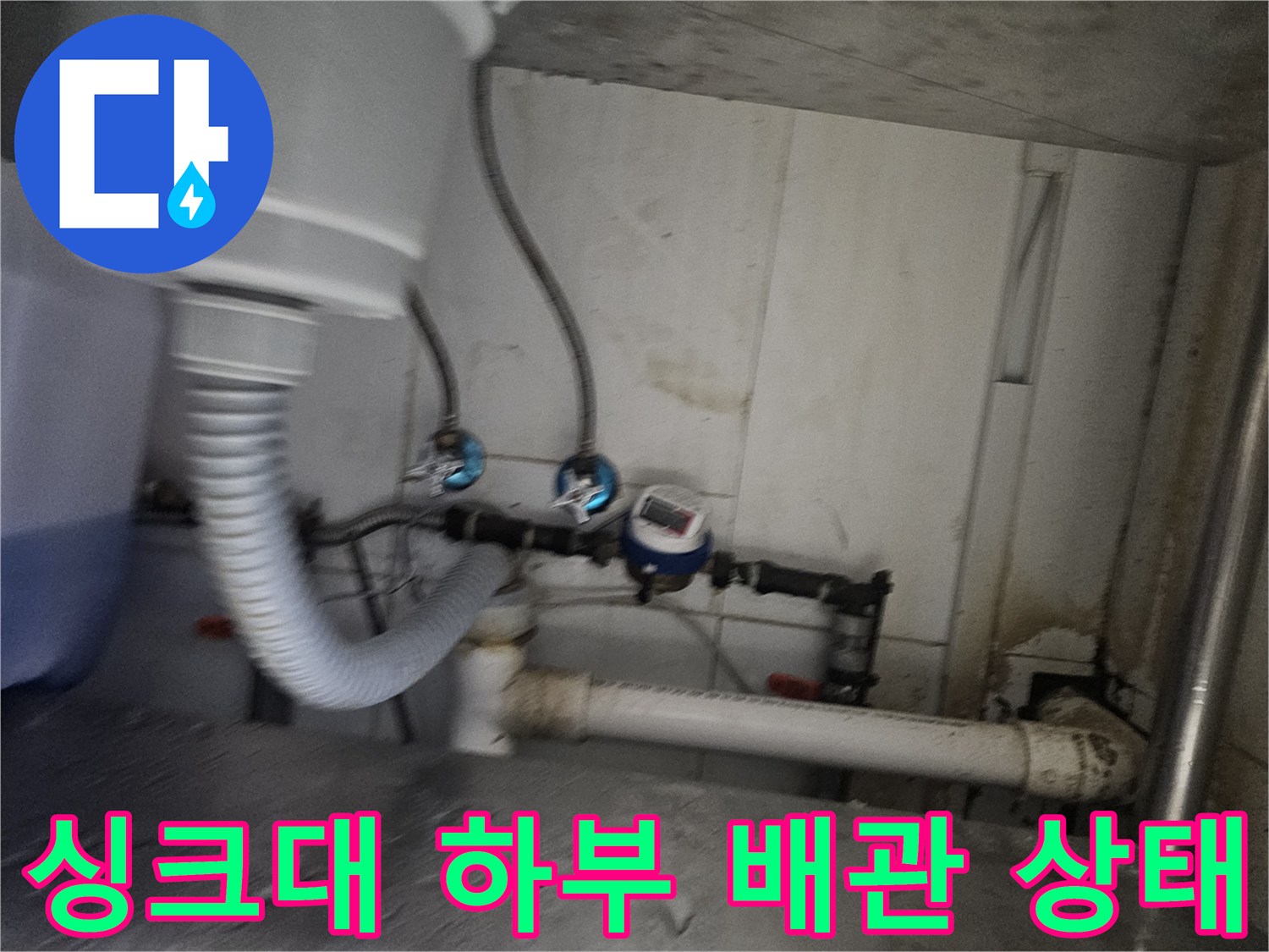 싱크대 아래쪽 밸브와 연결 호스의 복잡한 구조물 촬영