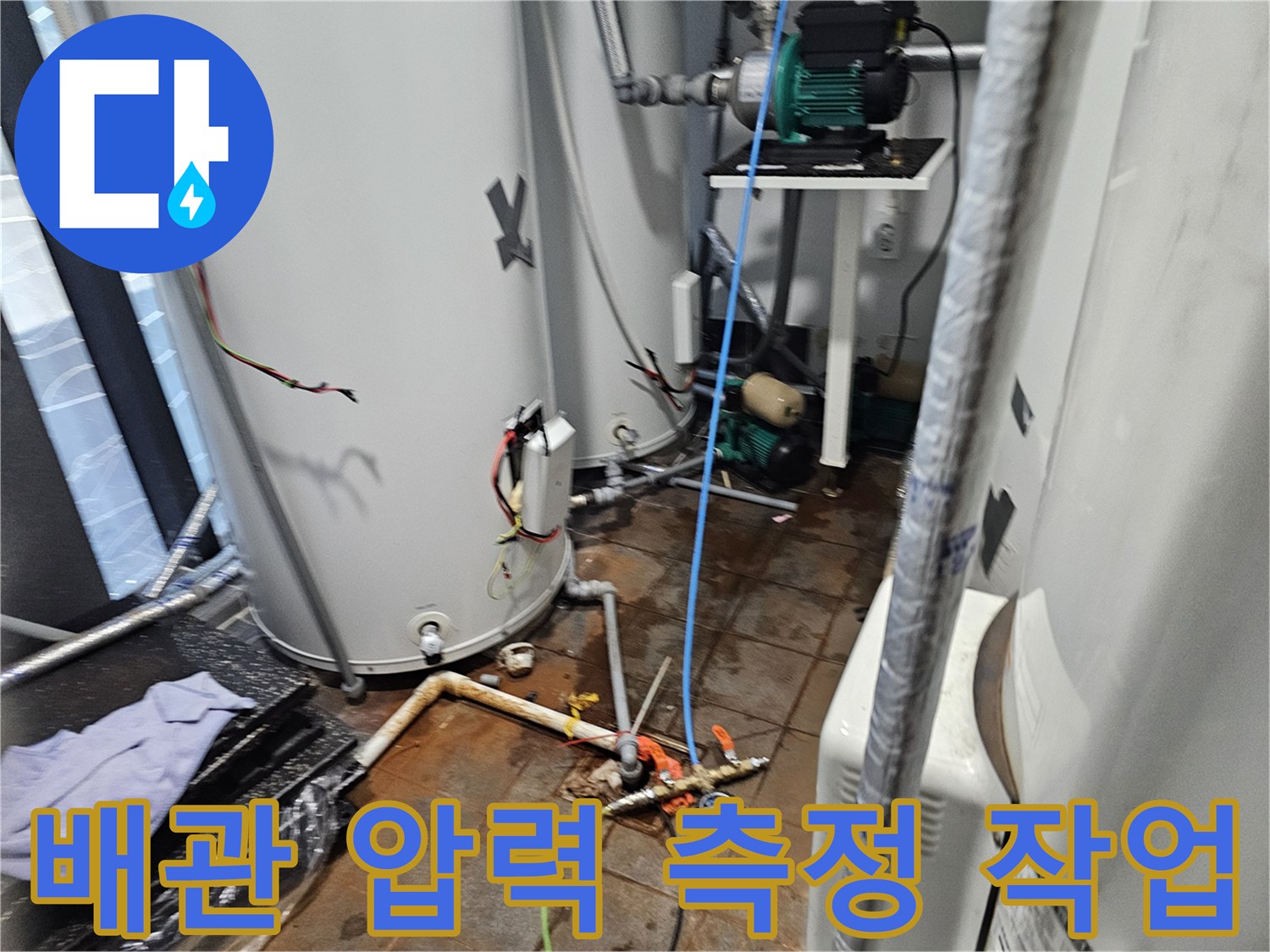 온수 탱크 주변 배관에 연결된 누수 탐지용 장비와 호스 모습