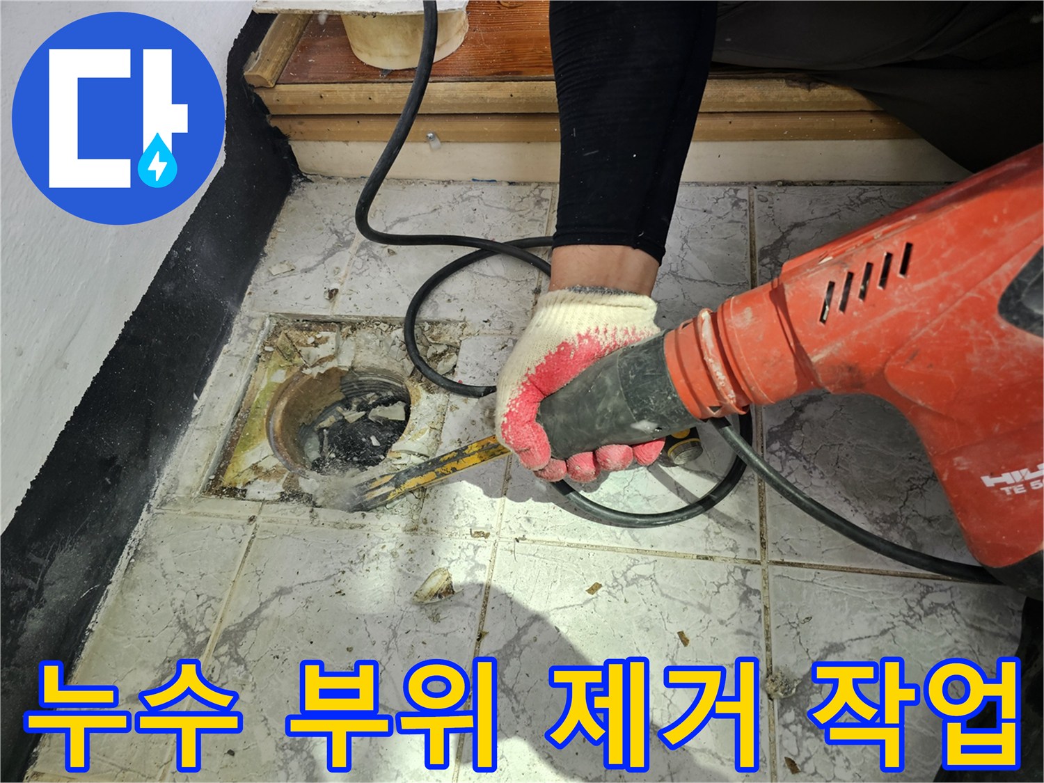 우수관 주변의 깨진 타일과 시멘트를 걷어내는 공사 현장