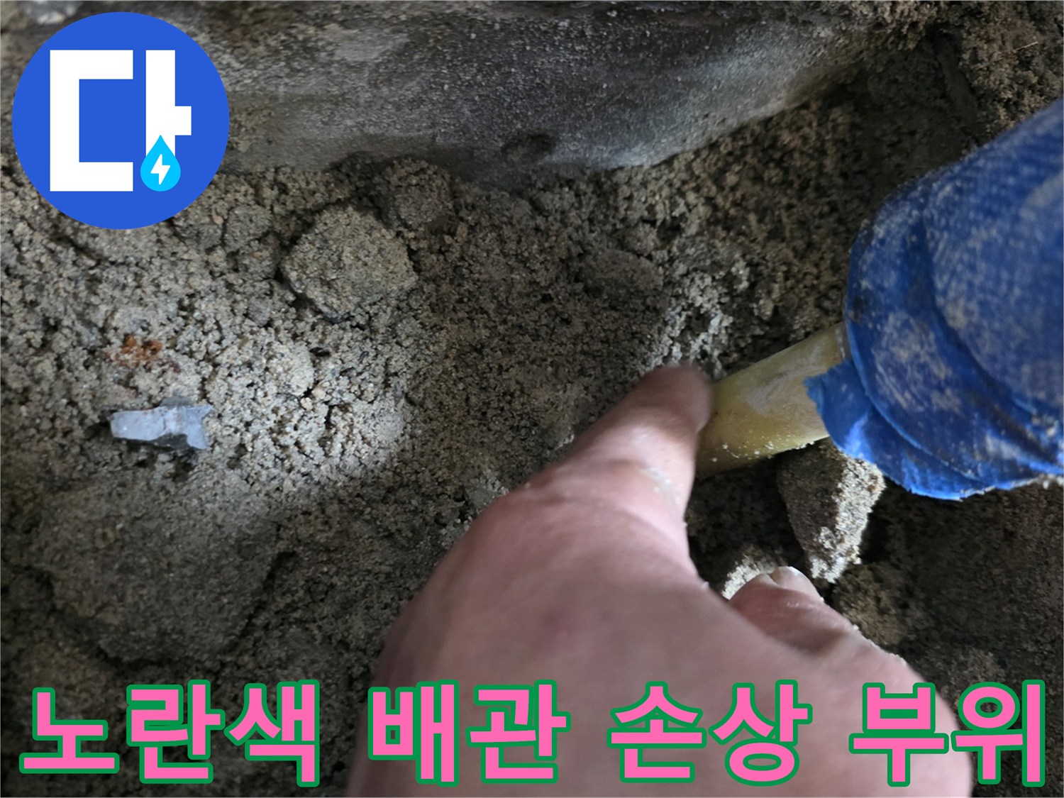 파헤쳐진 흙 속에서 드러난 노란색 배관과 작업 도구