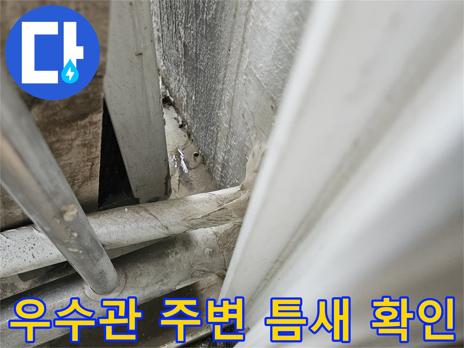 베란다 우수관 하단-배관 주변 틈새와 오염 상태를 보여주는 사진
