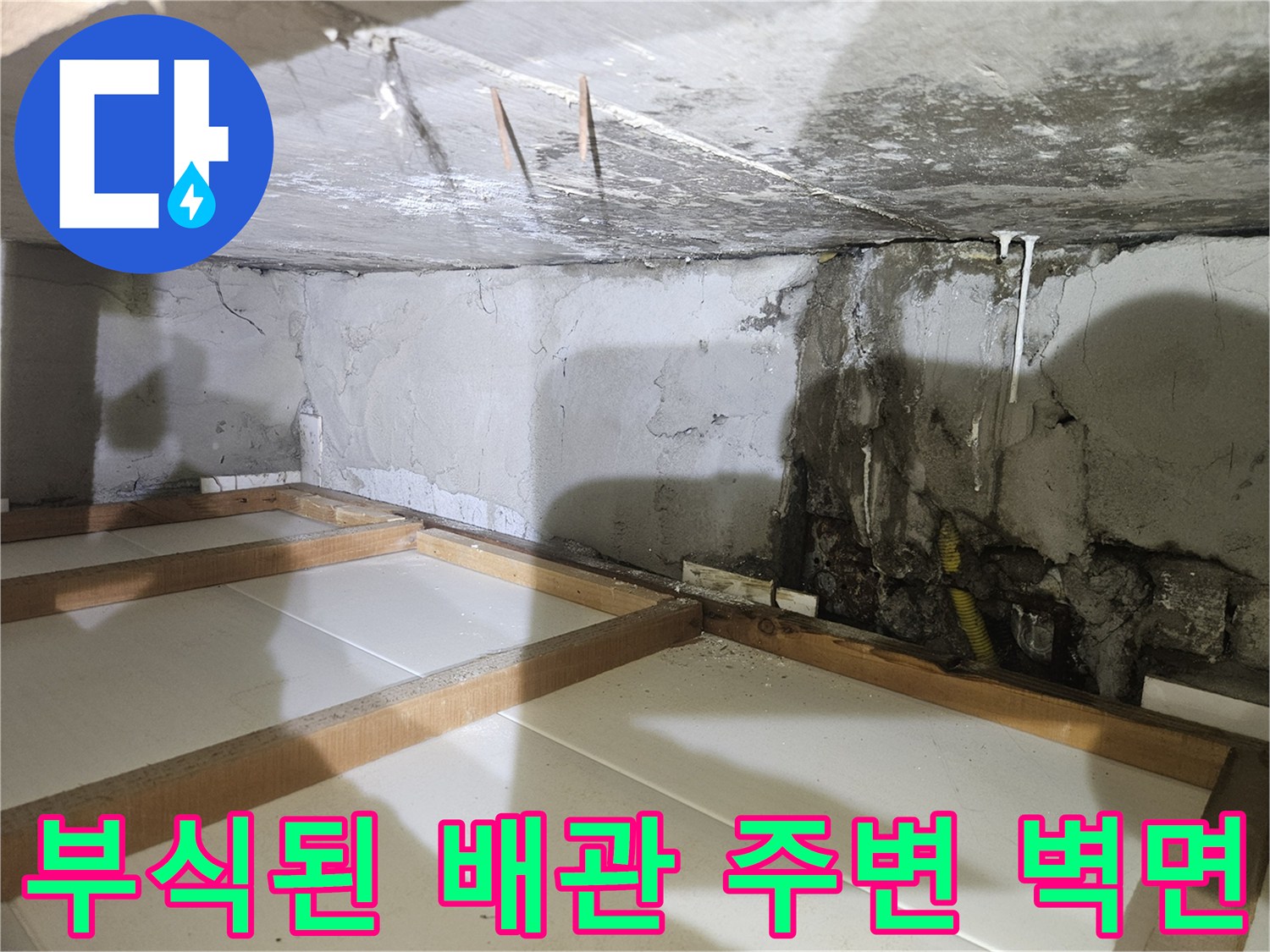 습기로 인해 변색되고 젖은 콘크리트 벽면과 노출 배관