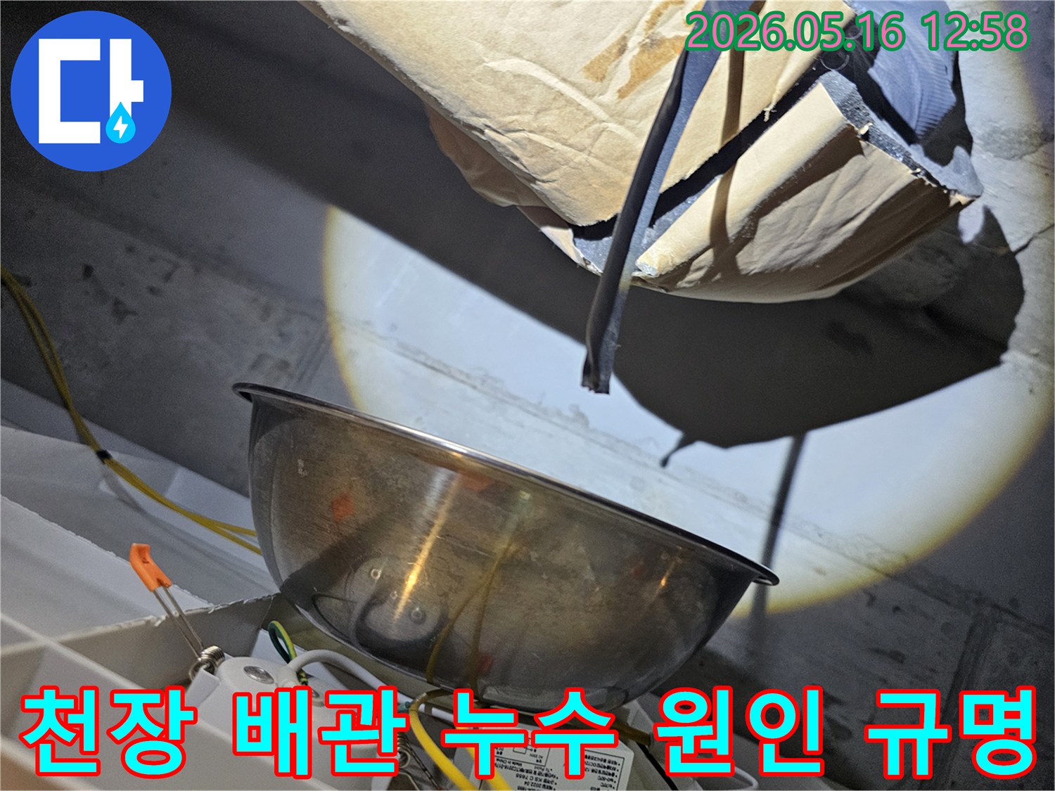 어두운 천장 속에서-강력한 조명으로-배관의 미세한 누수 지점을-정밀하게 규명하는-전문가의 모습입니다