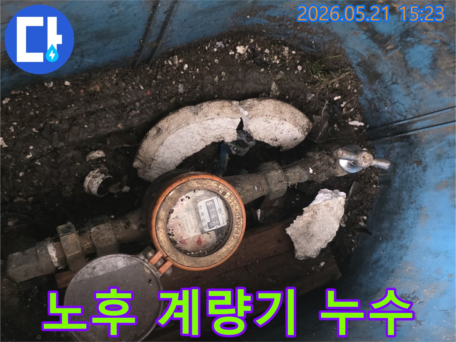 오래된-수도계량기와-주변의-젖은 흙-그리고-파손된-단열재를-보여주는-현장-사진