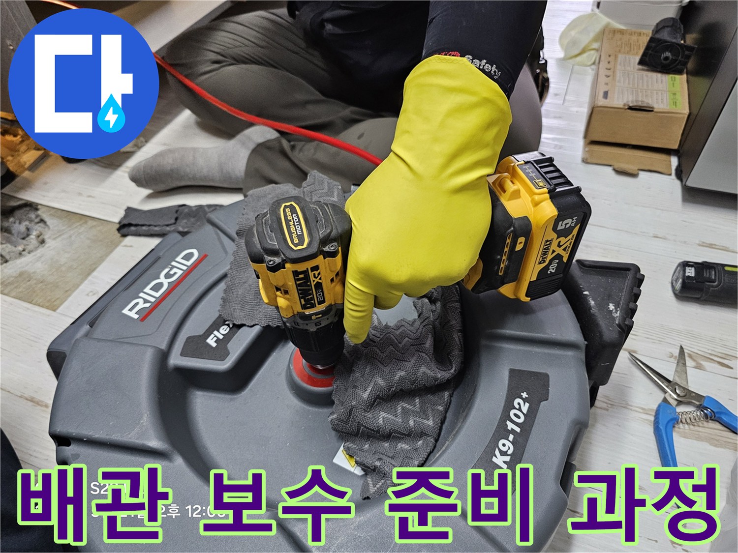 작업자가 전동 드릴을 사용하여 배관 주변 작업을 진행하는 모습