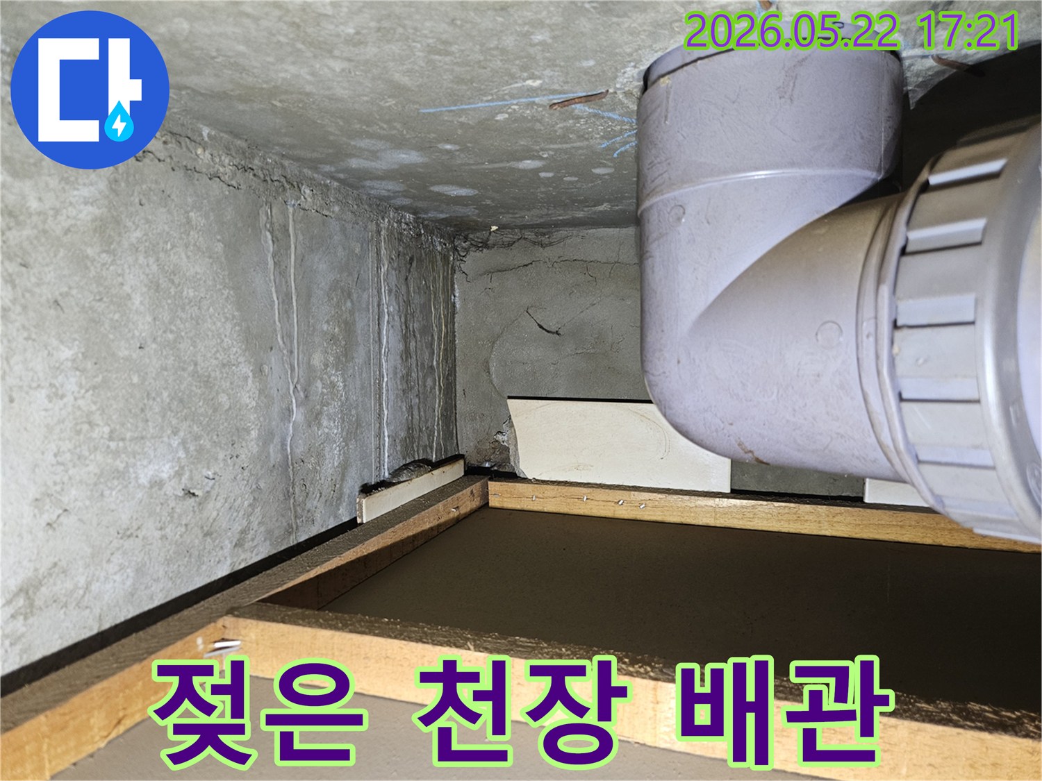 아파트 천장 모서리 부분에 나타난 물 얼룩과-배관 주변의 습기로 인한 누수 상황을 담고 있습니다.