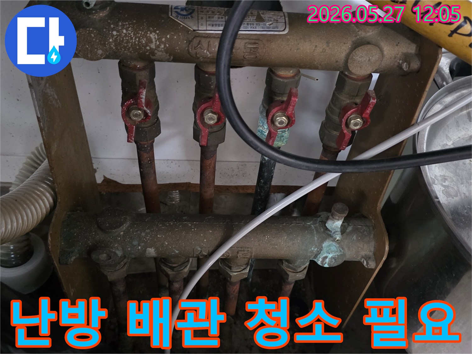 오래된 아파트의 보일러 분배기 배관에-녹물과 이물질이 쌓여-난방 배관 청소가 필요한 현장을-전문가가 점검하고 있습니다