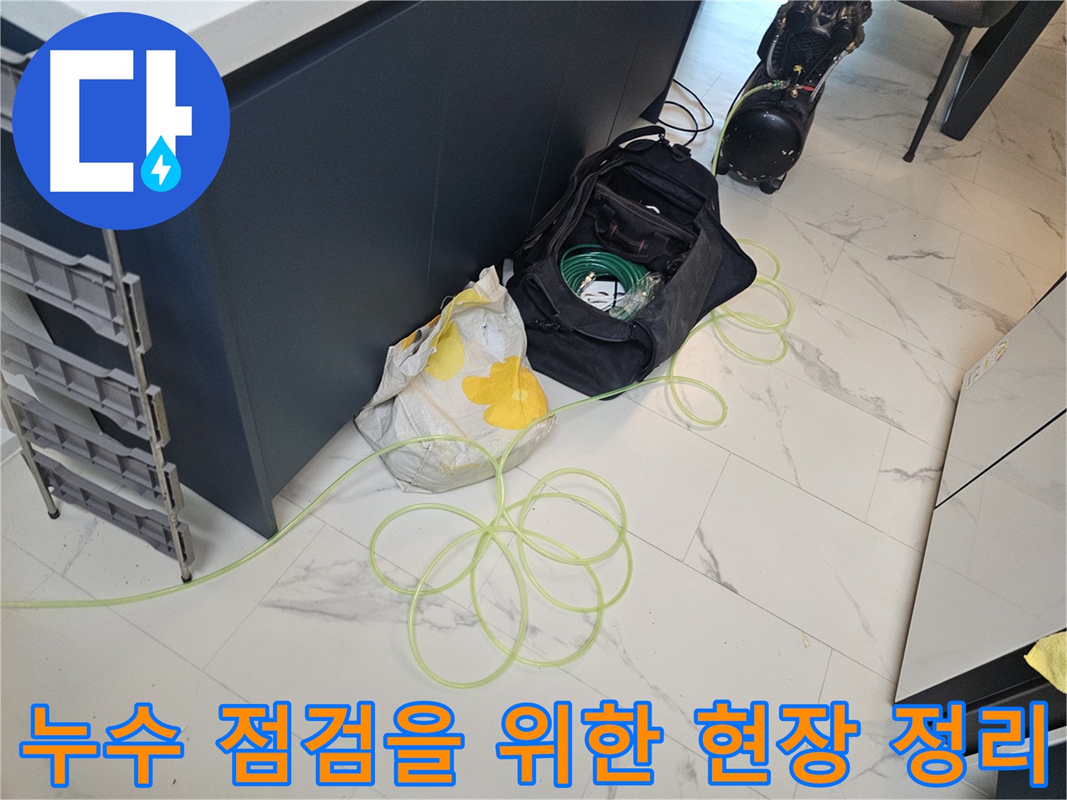 작업 준비를 위해-싱크대 하부 바닥에 놓인 자재와 호스