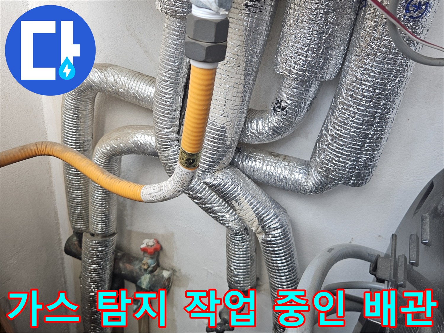 노란색 호스가 연결된 - 은색 보온재 마감 배관의 모습입니다