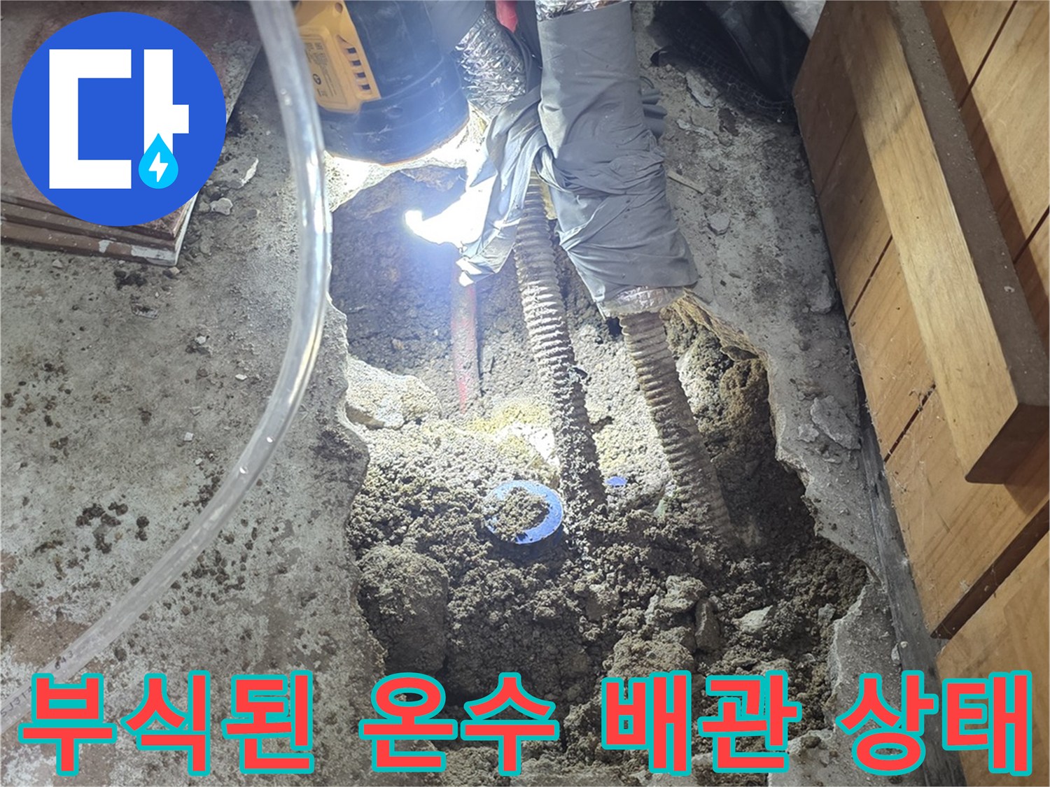콘크리트 아래 드러난 부식되고 구멍 난 금속 배관