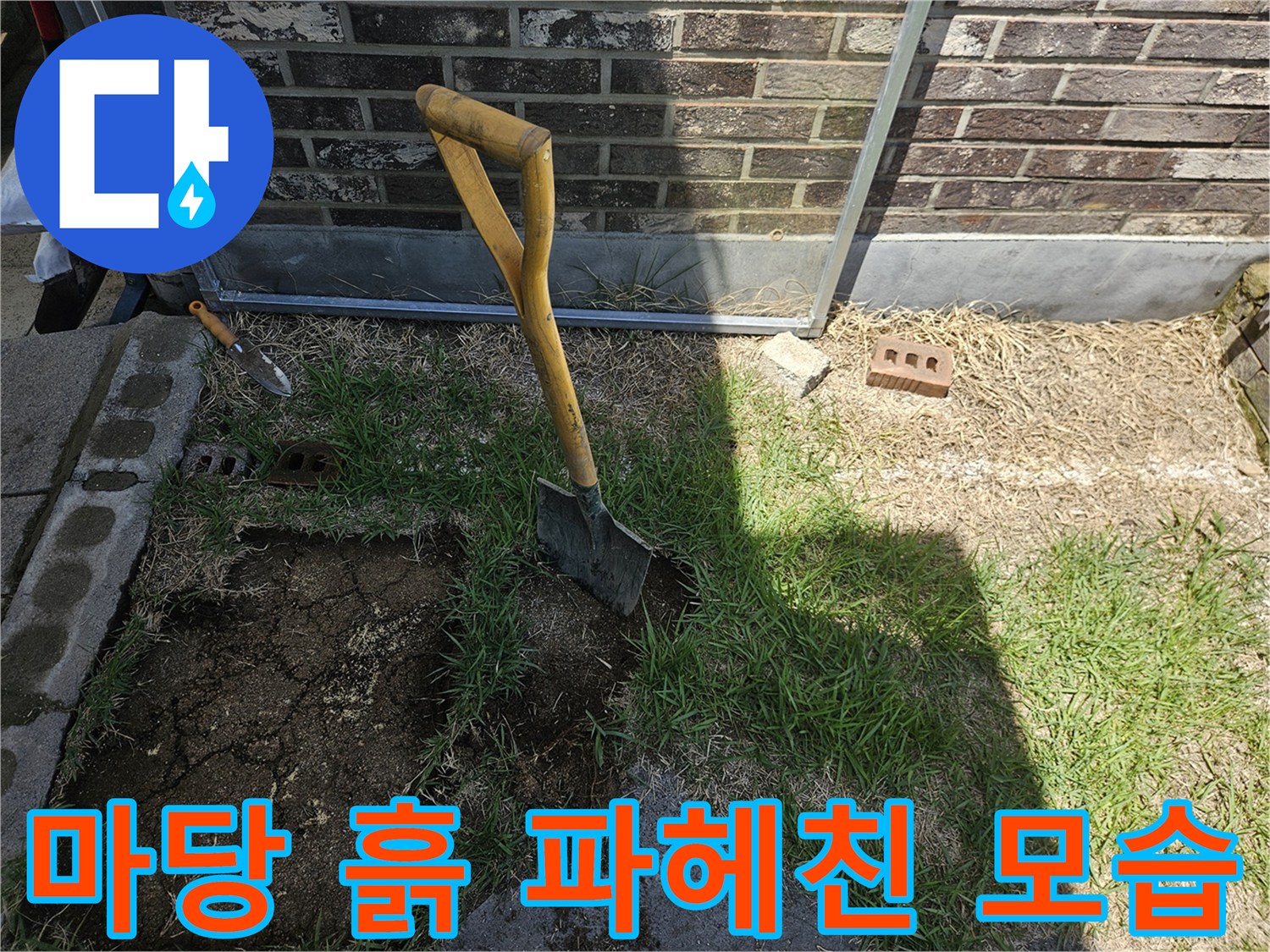 삽으로-파헤쳐진 마당의 흙과 작업용 도구가 놓인 현장 사진입니다.