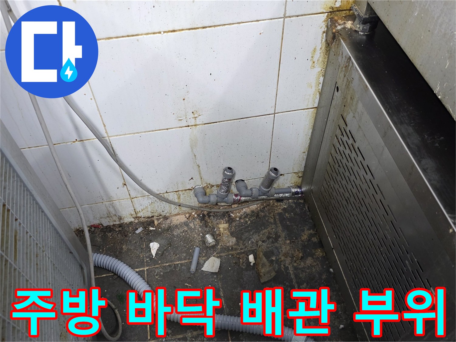 주방 하단 구석에 노출된 수도 연결 장치들