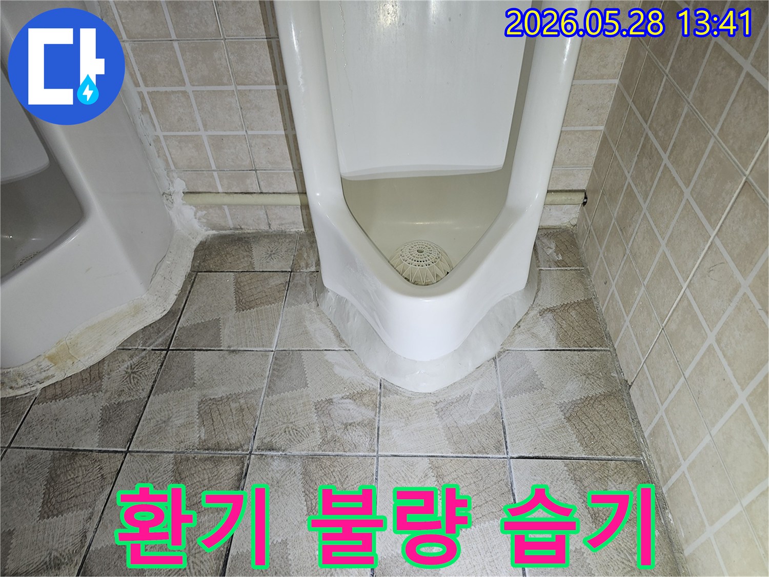 이 사진은-화장실 소변기 주변의-누수가-환기 불량으로 인한-지속적인 습기 문제와-관련될 수 있음을-보여줍니다