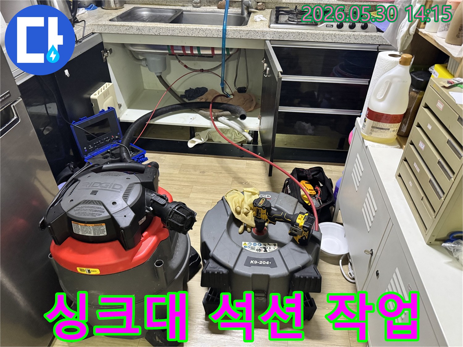 싱크대 하부에서-누수 탐지 중-배관 석션 작업을 진행하는-전문 장비 모습
