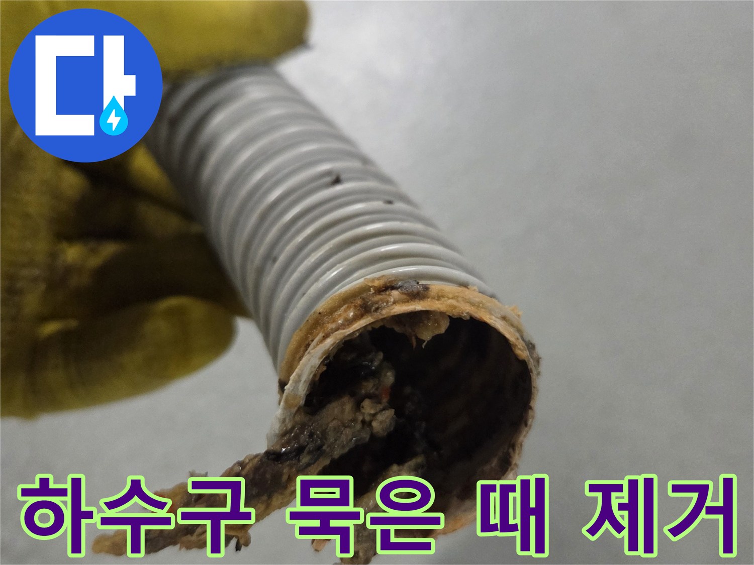 노란색 장갑을 낀 손이-오랜 시간 사용으로 더러워진 배수관을 보여주고 있습니다.