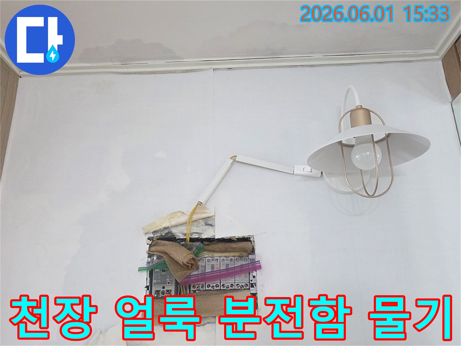 천장에 넓게 퍼진 물 얼룩과 함께-분전함 주변으로 물이 새어 위험한 상황을 보여주는 누수 현장입니다