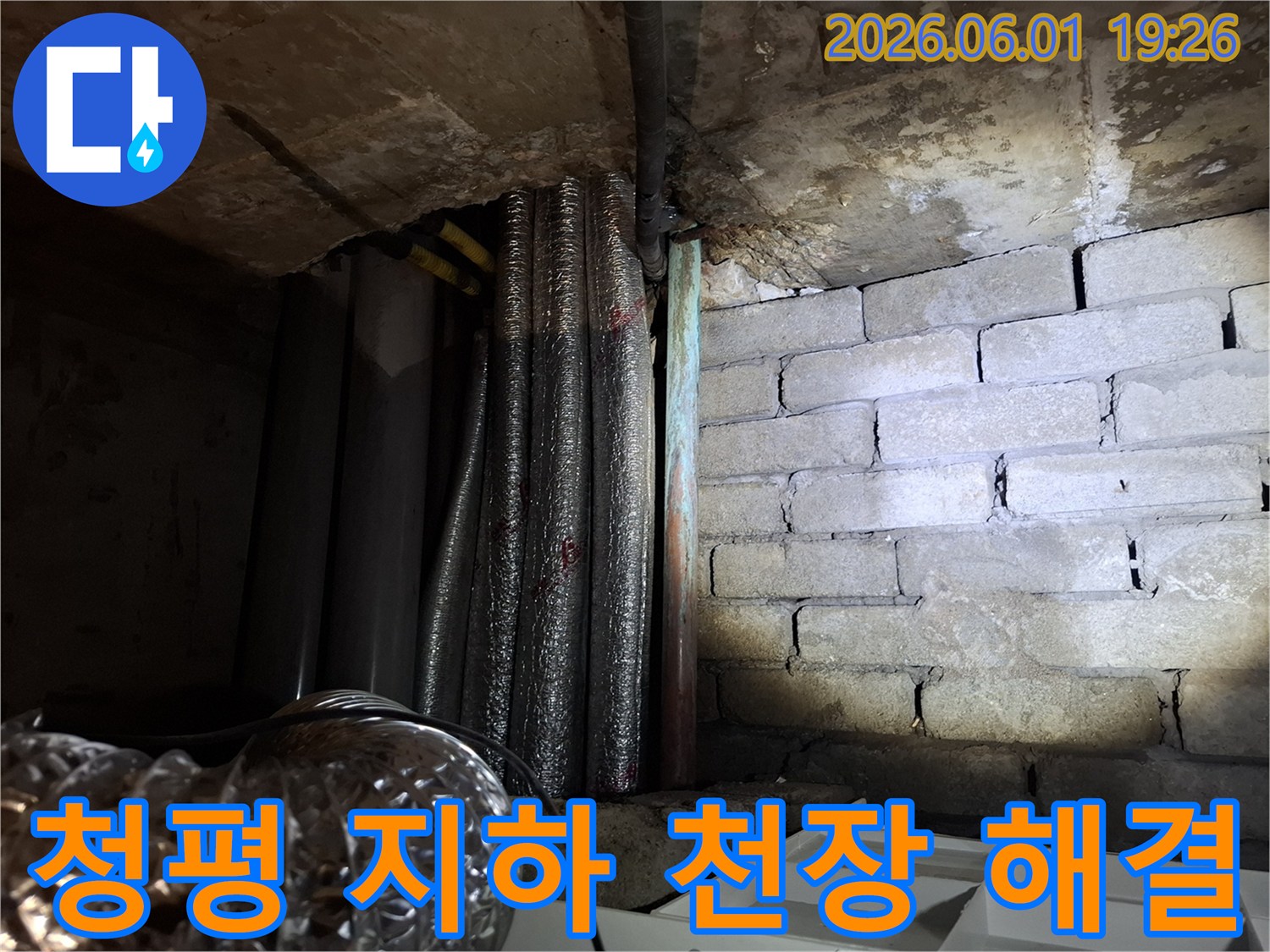 어두운 지하 공간에서-천장 콘크리트와-배관-그리고 젖은 벽돌 벽면의-누수 현장 모습입니다