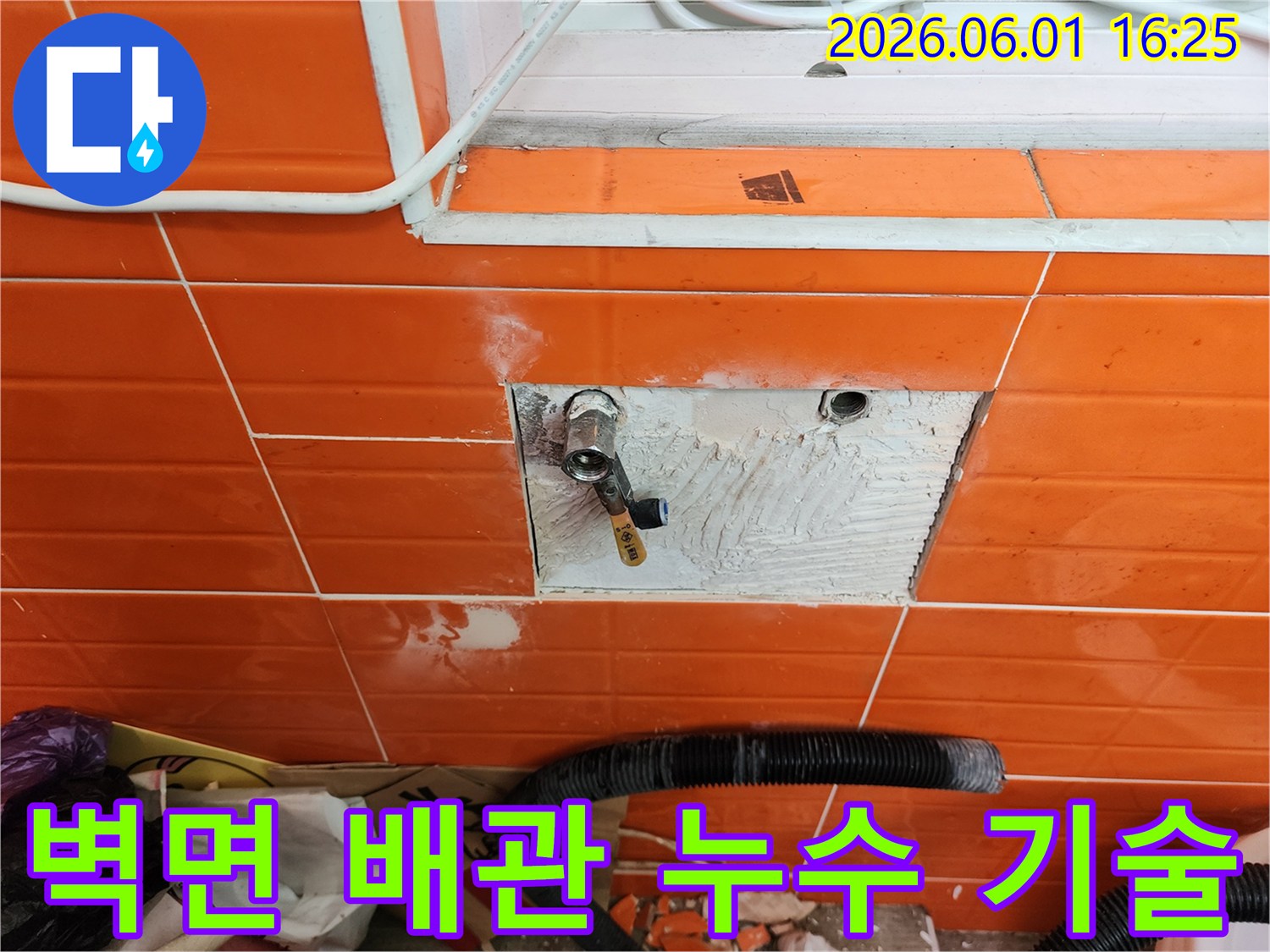 오렌지색 타일 벽면의-배관 누수를-전문 기술로 해결하기 위해-타일을 제거하고-배관을 수리하는 작업 현장