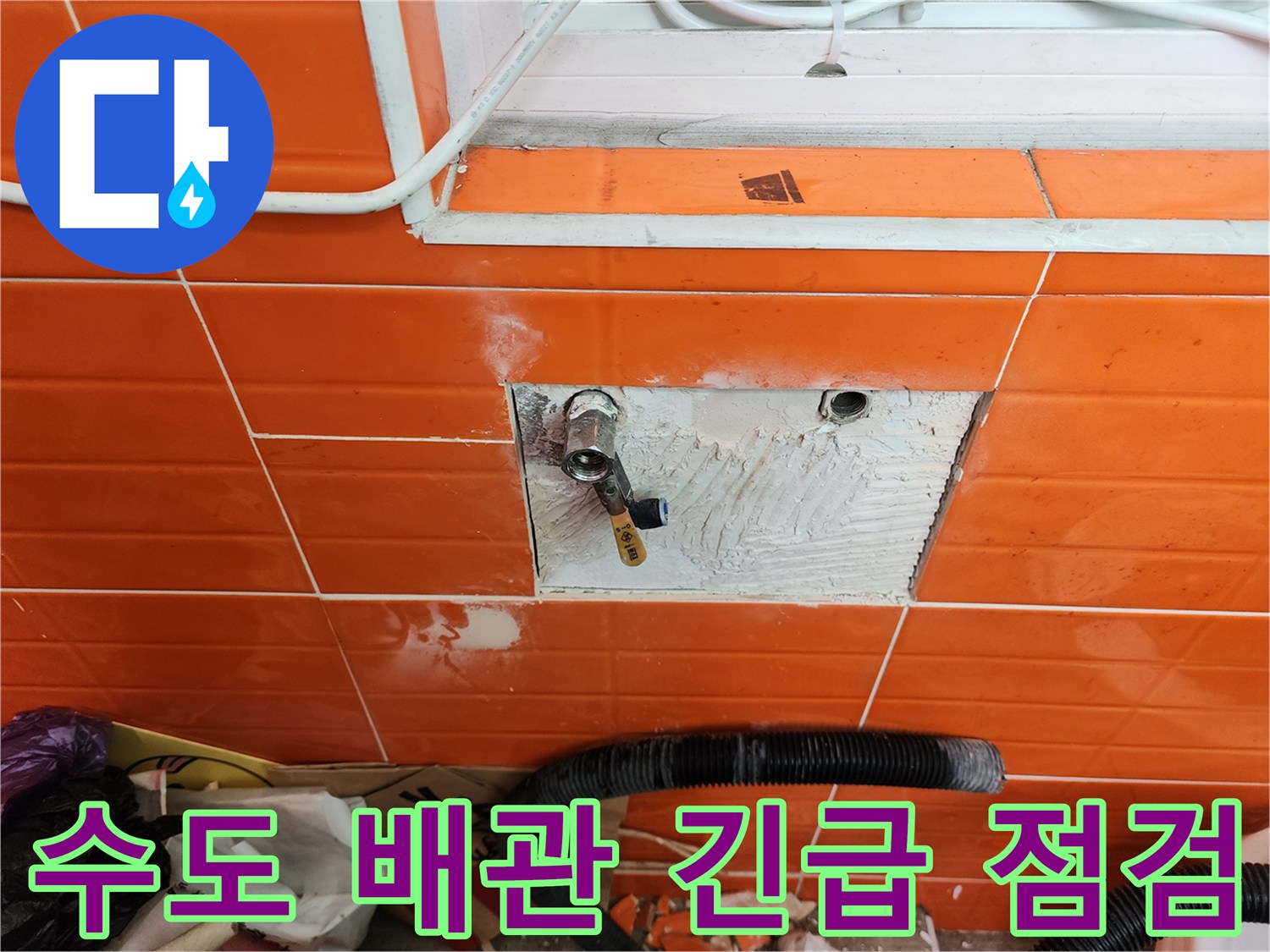 오렌지색 타일 벽면의-수도 밸브 주변에서-누수 여부를 긴급 점검하는 모습
