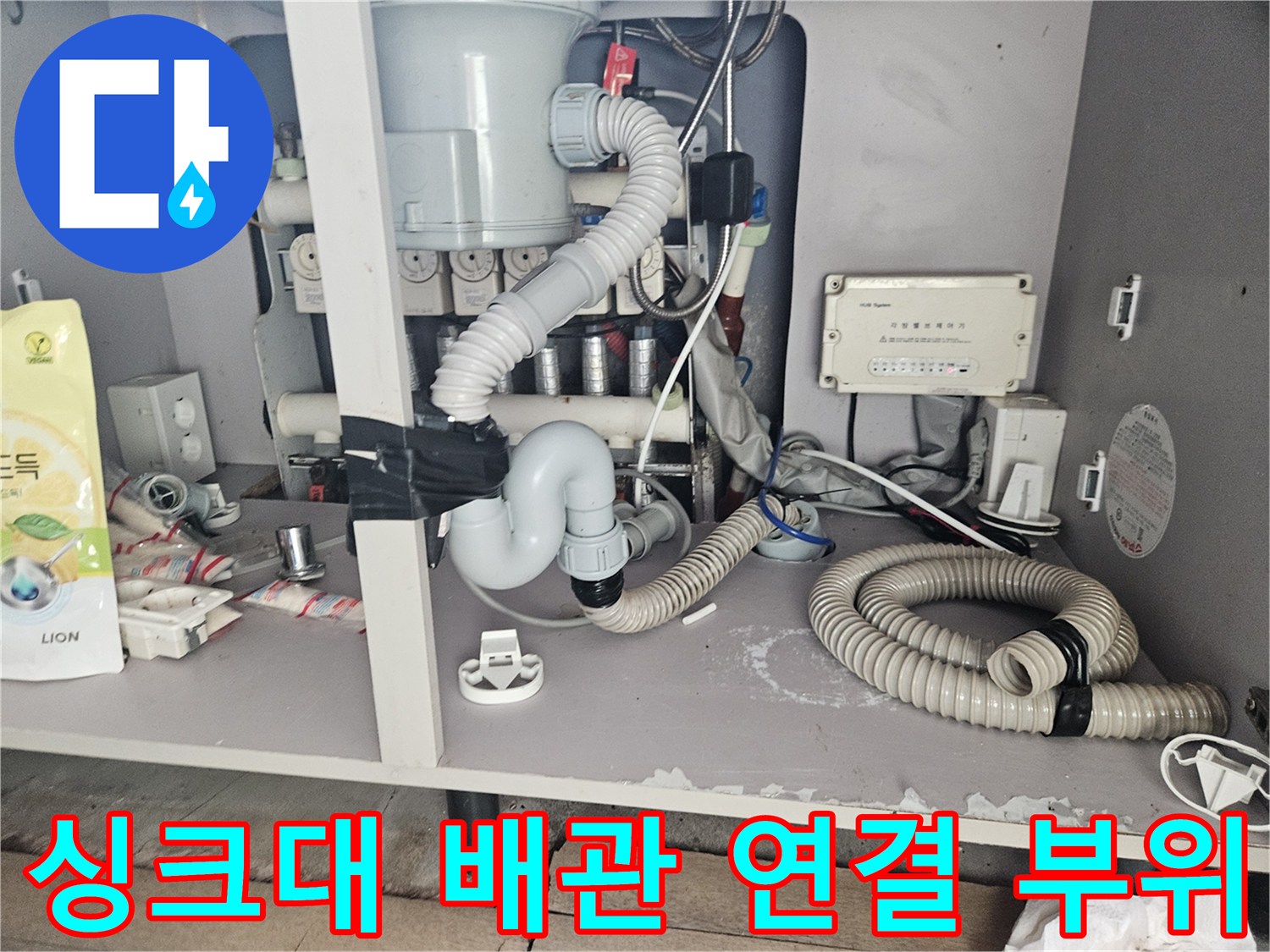 복잡하게 얽힌-싱크대 하부 배수 호스와 주름관의 상세 모습입니다.