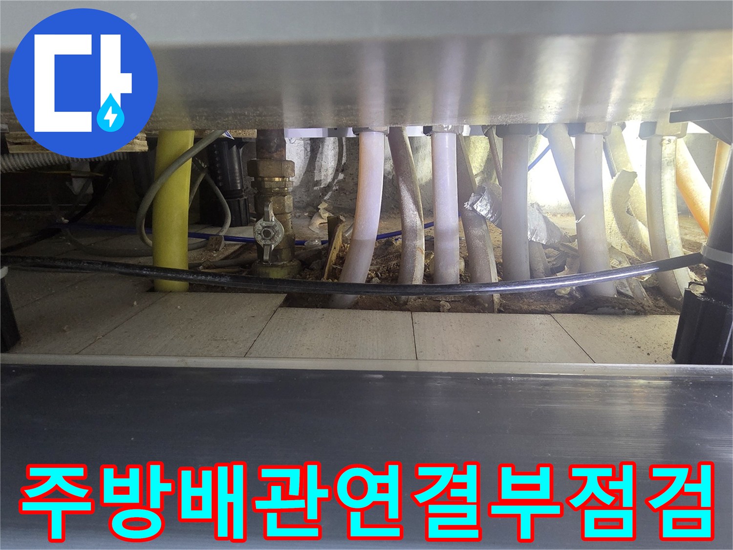 싱크대 아래쪽 보일러 분배기와 연결된 각종 수도 배관 모습