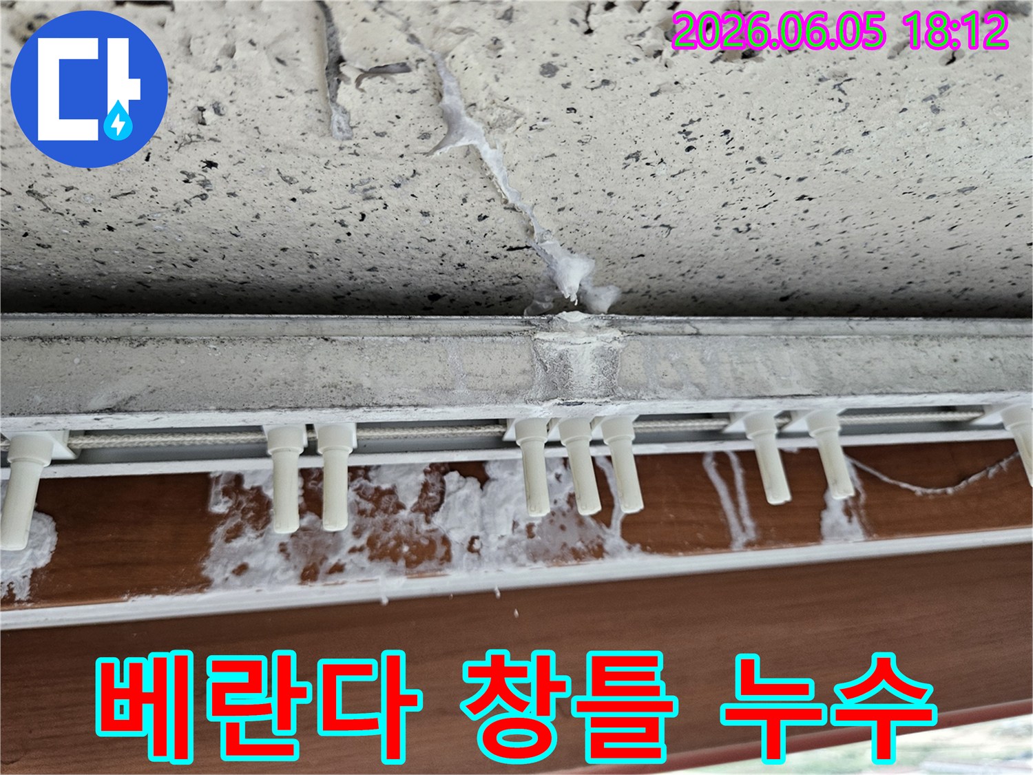 베란다-창틀-아래-벽면에-발생한-누수-자국과-오염된-실리콘-상태를-보여주는-클로즈업-사진