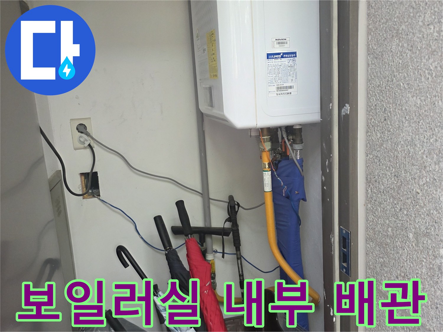 흰색 가스보일러 하단에 연결된 각종 배관과 콘센트 모습