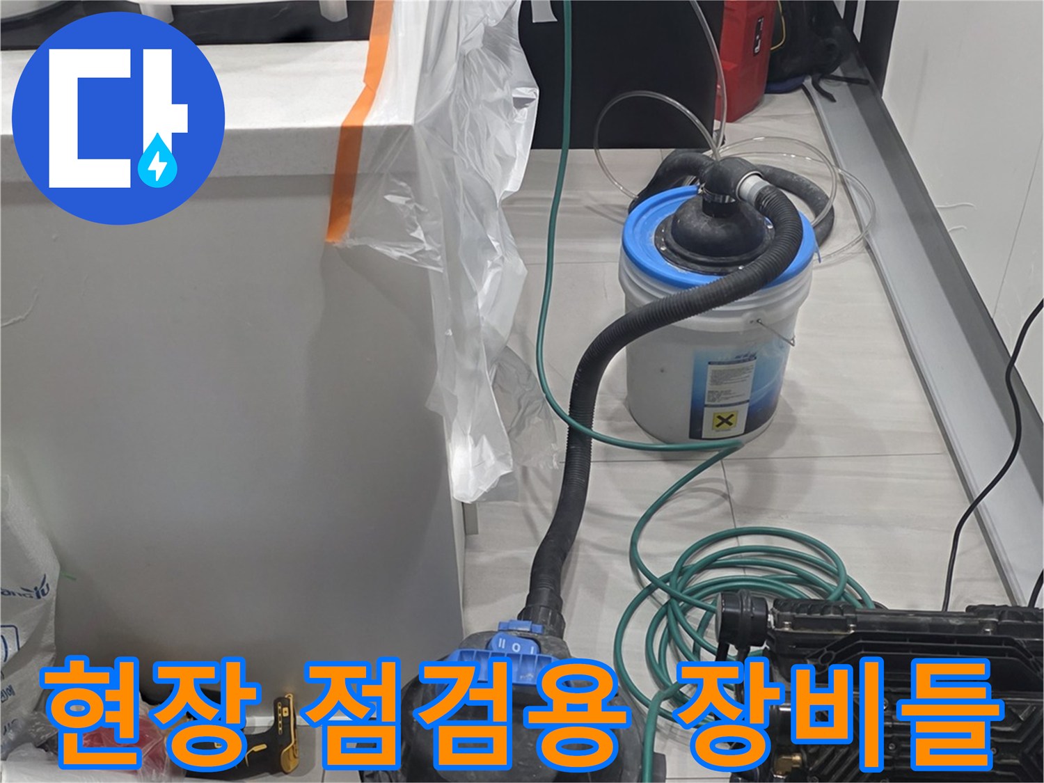싱크대 아래 좁은 공간에 배치된 배관 검사 및 청소용 전문 기구