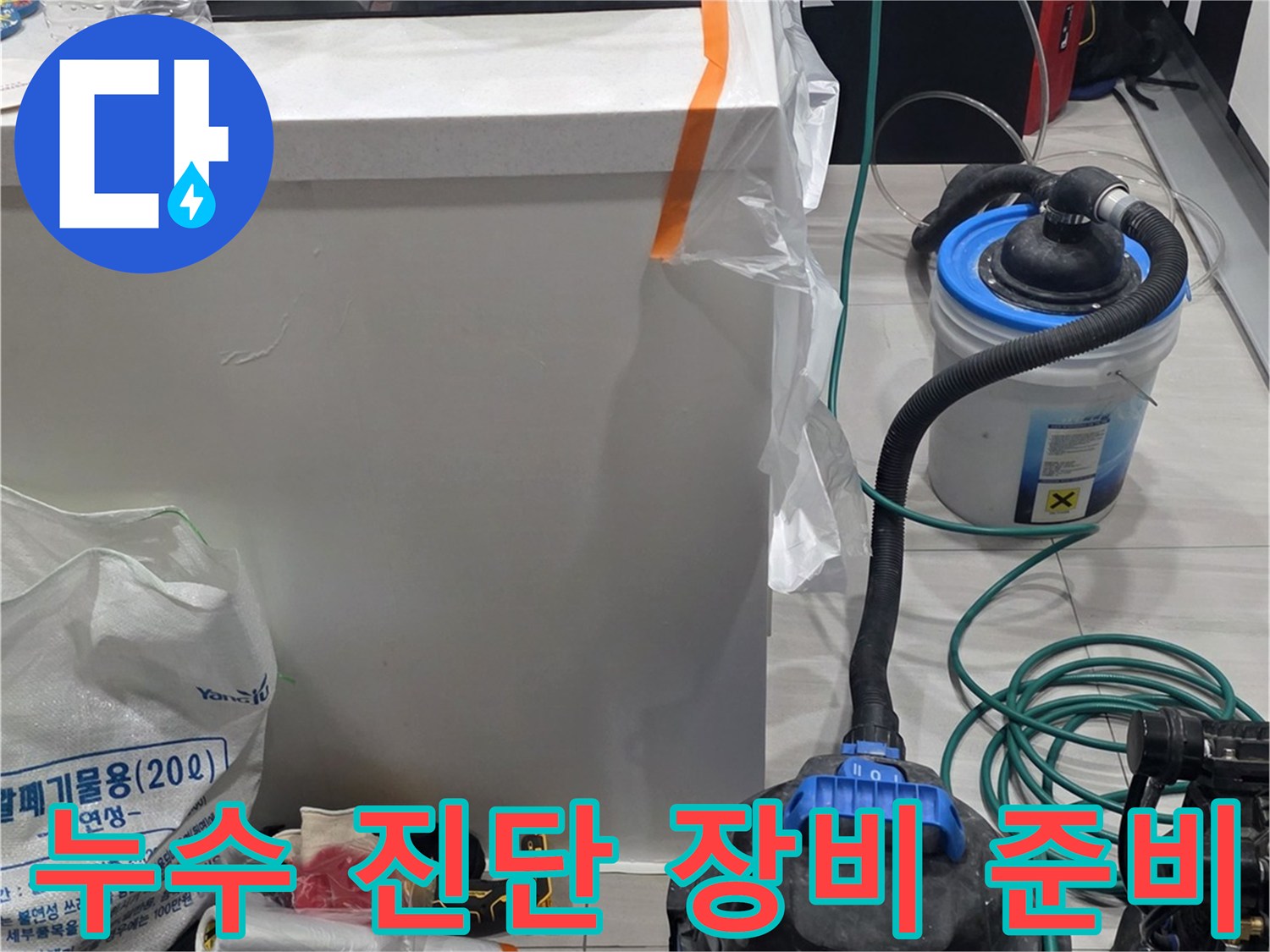 싱크대 하단 작업 구역에 배치된 누수 탐지 및 청소 도구들