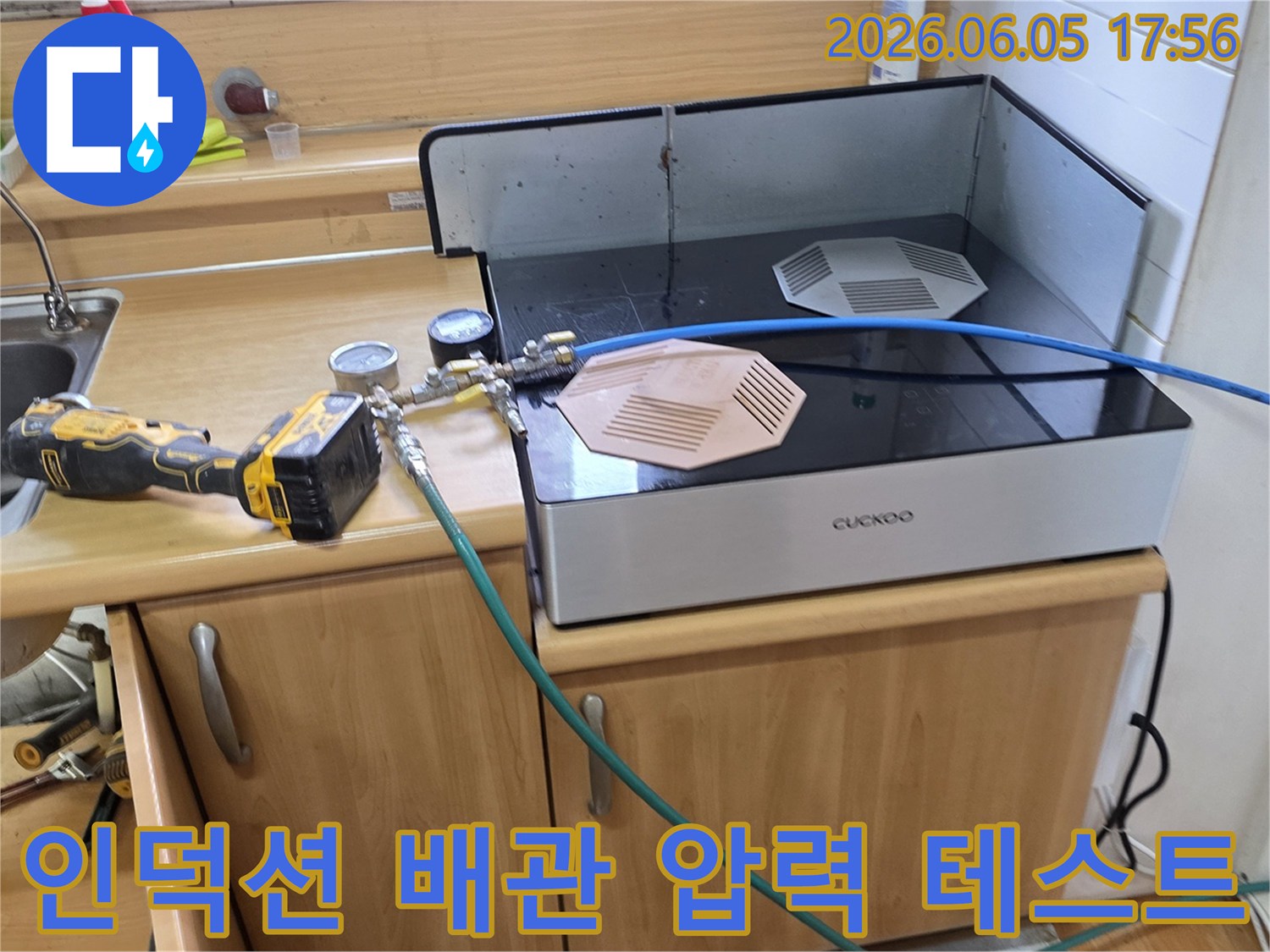 포천 하이츠빌라 주방에서-인덕션 아래 배관의 누수 여부를-확인하기 위해-압력 테스트 장비를 연결하여-진행하는 모습