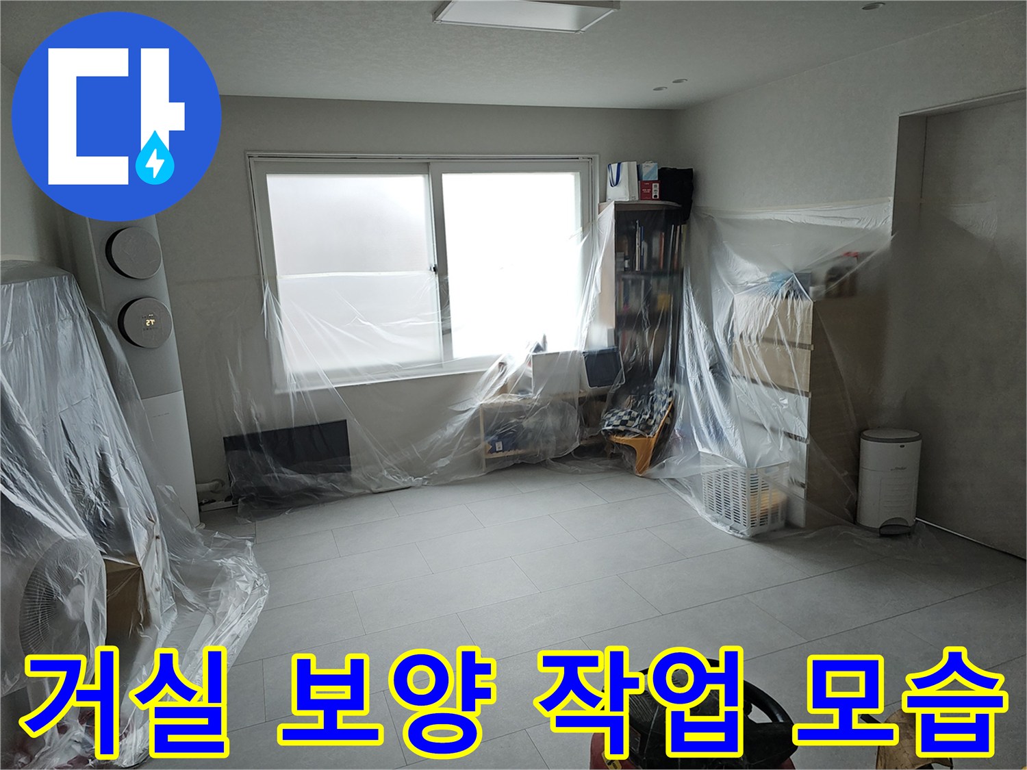 누수 공사를 위해 비닐로 가구와 벽면을 보호한 거실 내부 전경입니다.