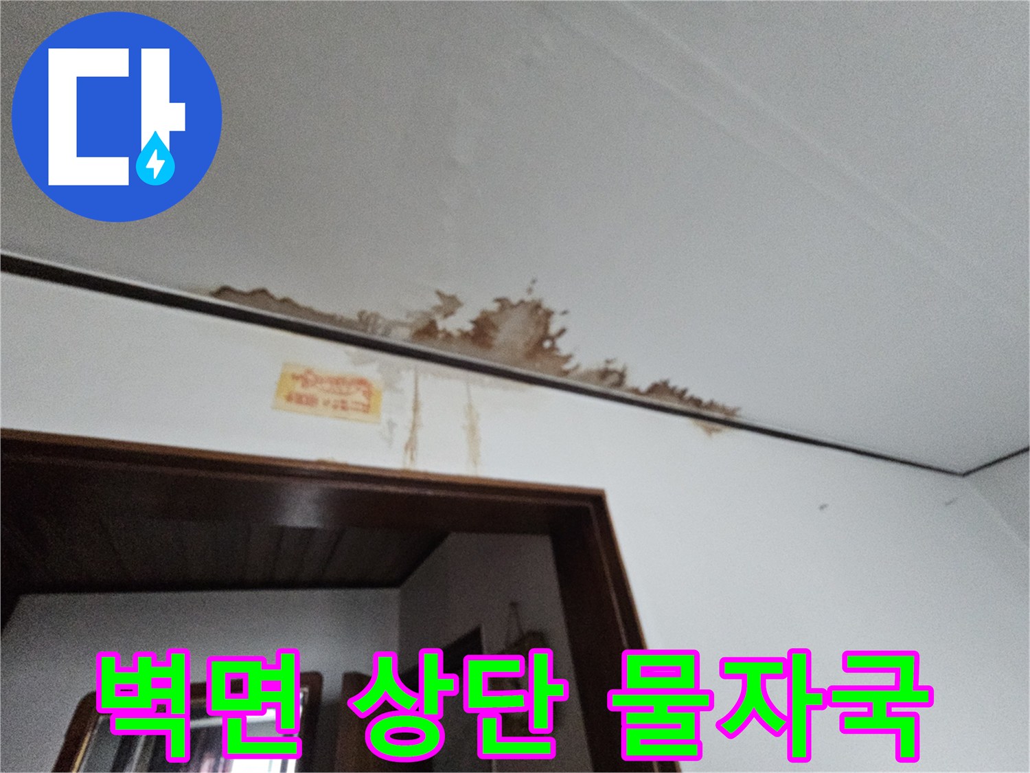 천장 몰딩 부근에 나타난 젖은 듯한 얼룩과 변색된 벽지