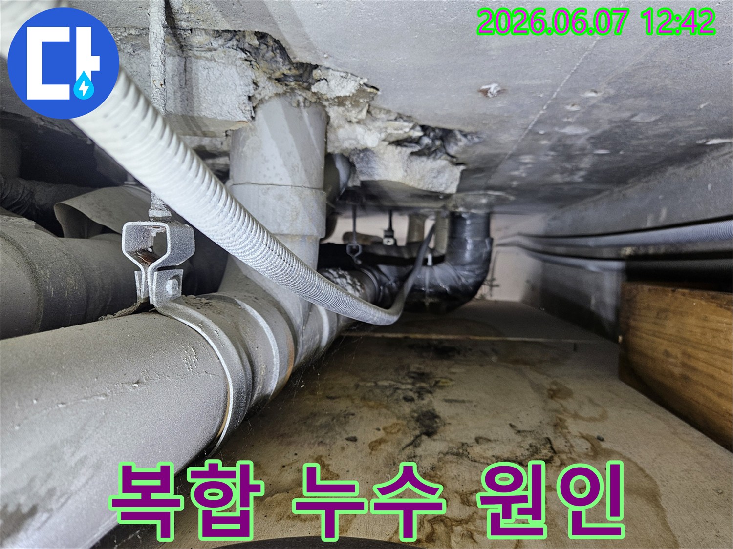천장 배관과 주변에서 물이 새어 나와-바닥에 물자국과-습기가 가득한-누수 현장의 모습입니다.
