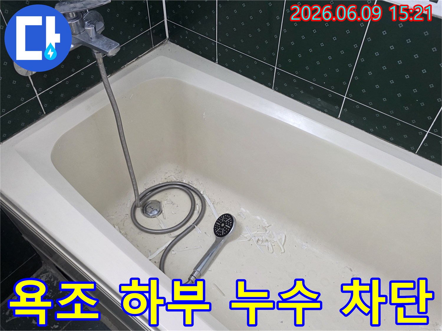 욕조 내부에서 누수 보수 작업 흔적과-샤워기가 놓여있는 모습으로-욕조 하부 누수 차단 현장을 보여줍니다.