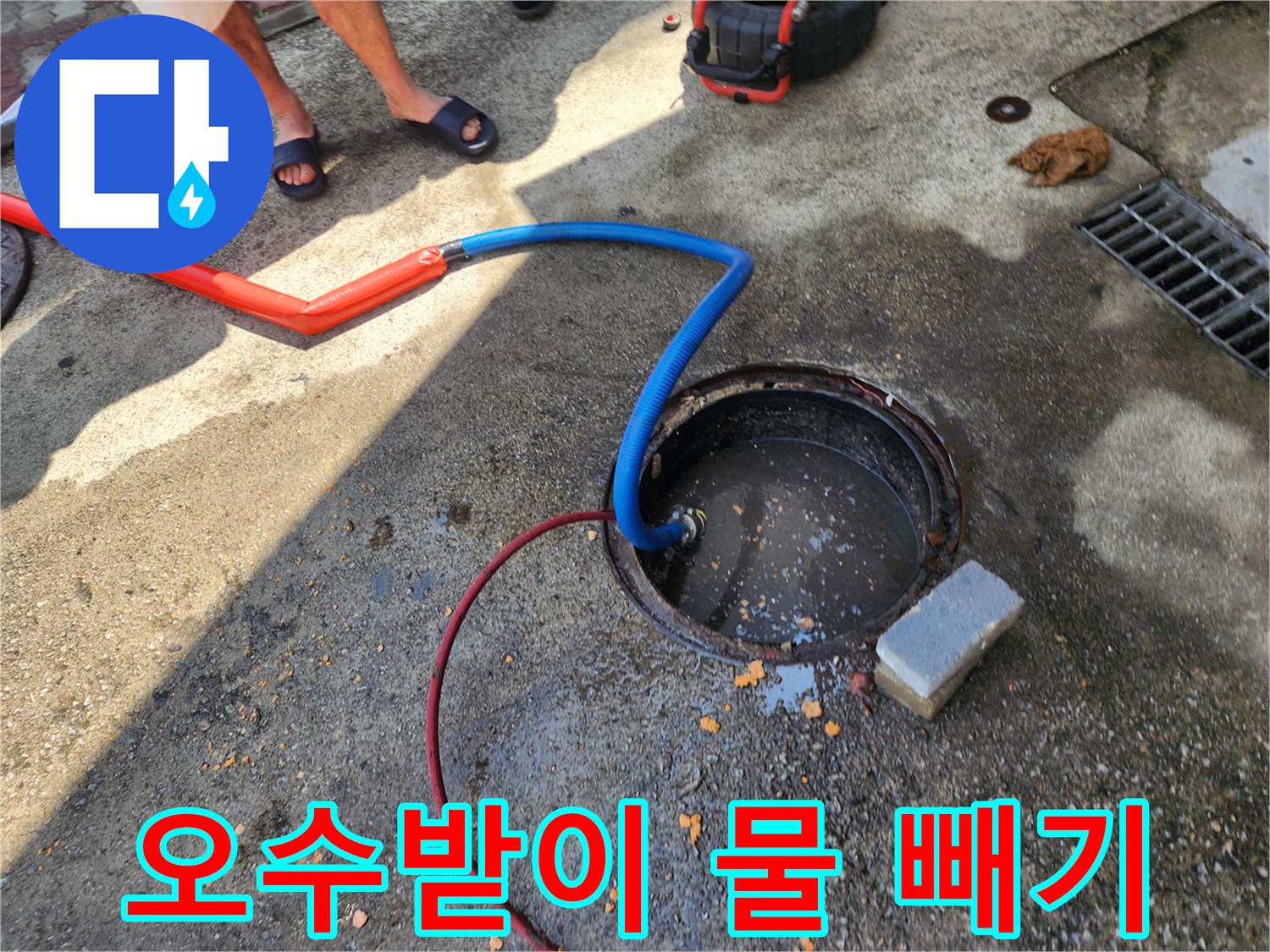 지면의-오수받이에-연결된-주황색과-파란색-배수 호스