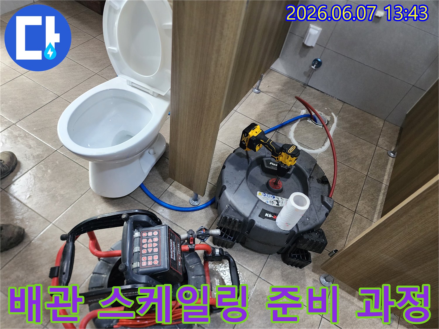 변기 옆 배관 작업을 위해 배치된 샤프트 장비와 드릴