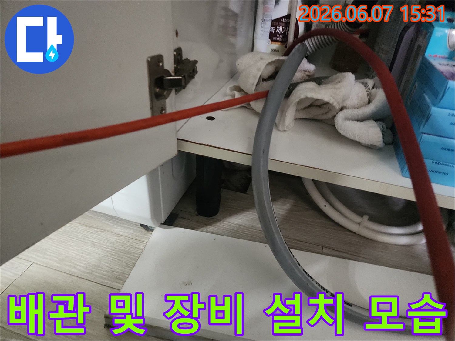 싱크대 하부 배관 주변에 배치된 작업 도구입니다.