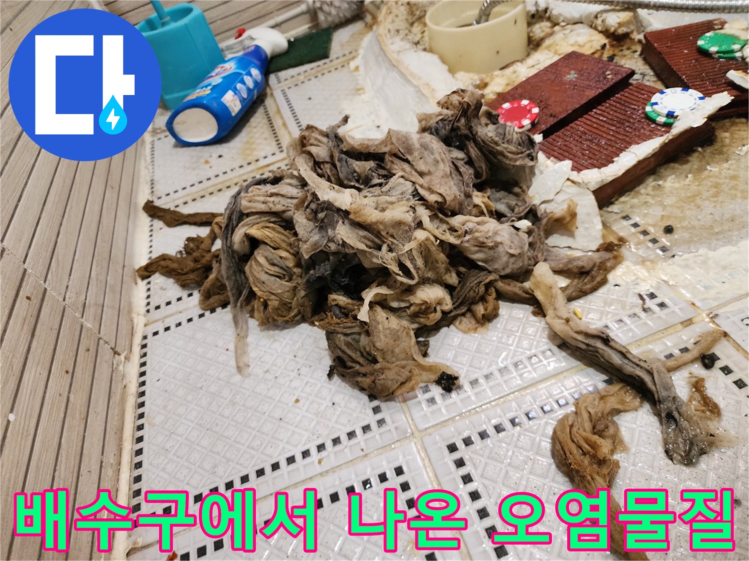 욕실 바닥 타일 위로 드러난 머리카락과 기름때 뭉치