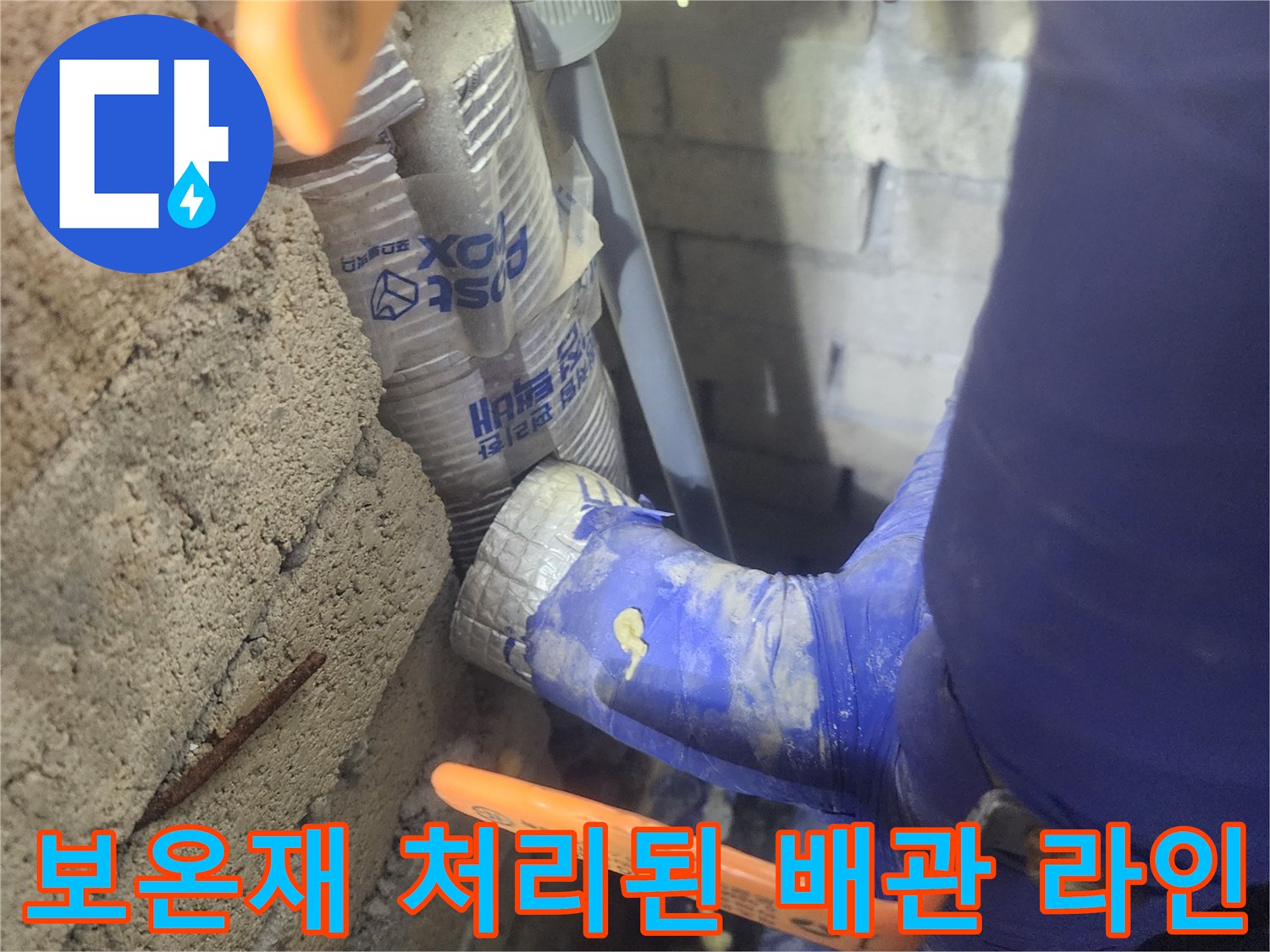 단열재가 씌워진-배관과 주황색 밸브 손잡이