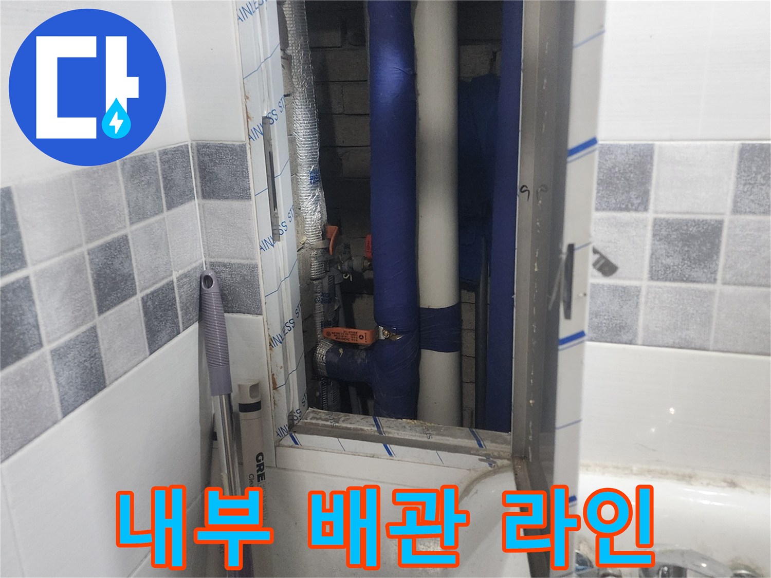 타일 벽면 점검구를 통해 드러난 내부 수도 배관 구조