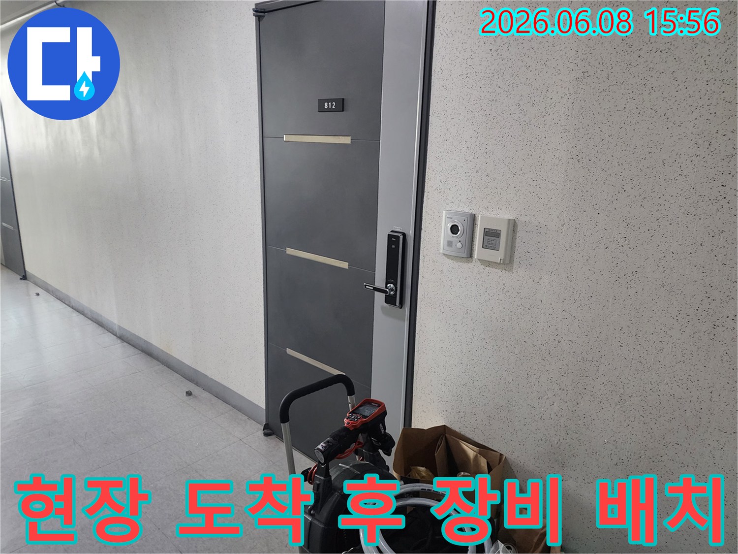 복도 문 앞 배관 청소용 석션기와 호스 뭉치 모습